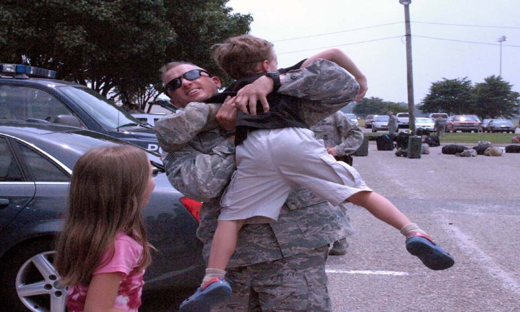 Technical Sgt. Troy Anderson, 4th Security Forces Squadron, reunites with his children Evan, 7, and Sydnie, 10, at Seymour Johnson Air Force Base, N.C., June 26, 2009. While deployed, 43 4th SFS Airmen contorlled all entry control and check points at Joint Base Balad, Iraq. (U.S. Air Force photo by Airman 1st Class Marissa Tucker)