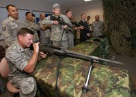 Tech. Sgt. Alexandro Bonilla, left, gives Brig. Gen. Len Patrick and Air Force Chief of Staff Gen. Norton Schwartz a hands-on tour of the Fire Arms Training Simulator used to teach tactics at the Inter-American Air Forces Academy security forces ground defense course June 26. General Patrick is the 37th Training Wing commander; Sergeant Bonilla is with the 318th Training Squadron.  (U.S. Air Force photo/Robbin Cresswell)