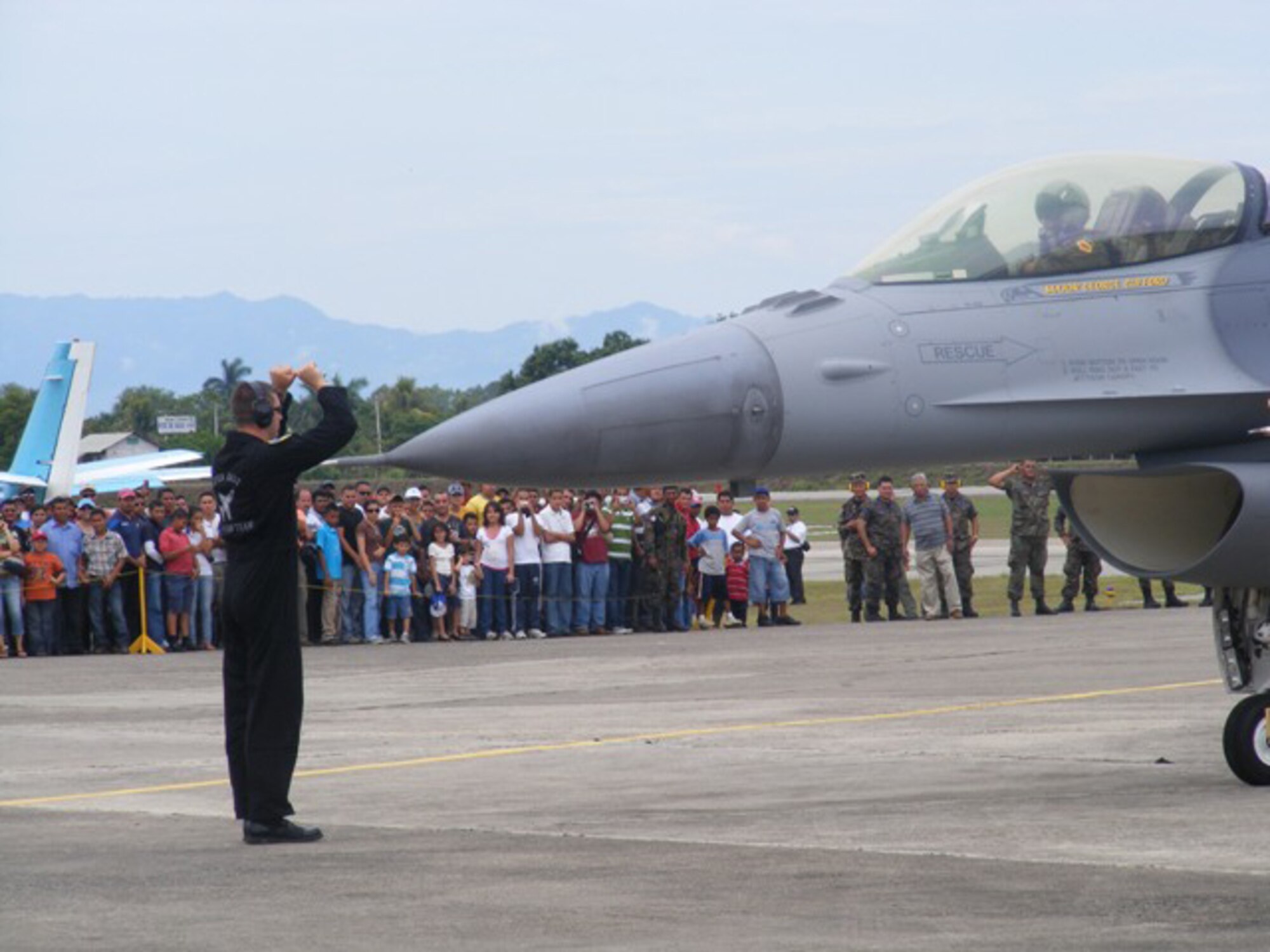 A crowd of air show attendees here cheer as a crew chief from the Viper East F-16 Demo Team marshals an F-16 after an aerial demonstration June 21. More than 30 Airmen participated at the international air show June 20-21. The more than $35,000 proceeds from the show will help build a children?s intensive care unit at a local hospital. 