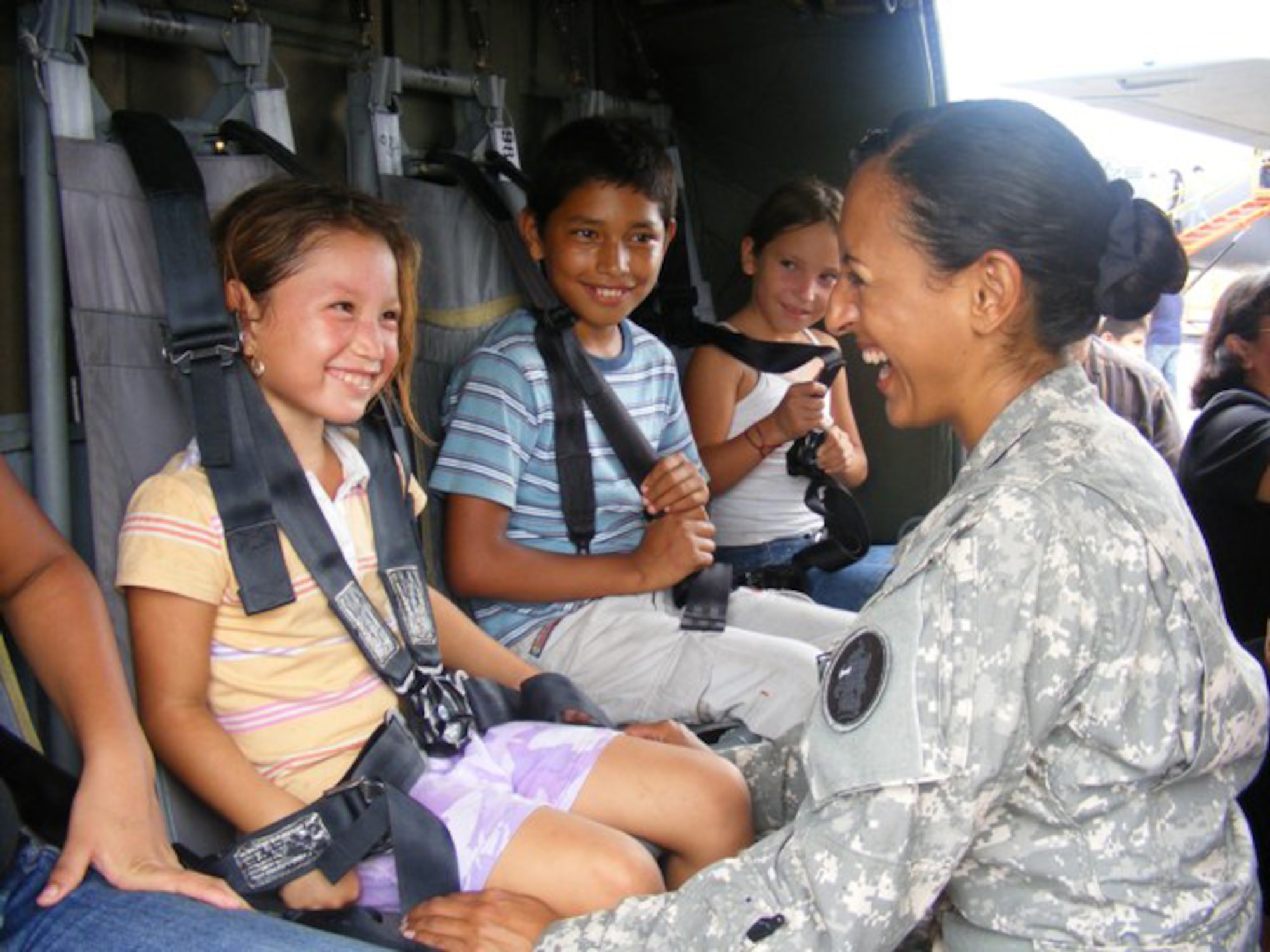 Army Capt. Vijay Gallardo, a UH-60 pilot assigned to Joint Task Force-Bravo, jokes with children during a static helicopter display at an air show here June 21. More than 30 Airmen and five Soldiers participated at the international air show June 20-21. The more than $35,000 proceeds from the show will help build a children?s intensive care unit at a local hospital. 