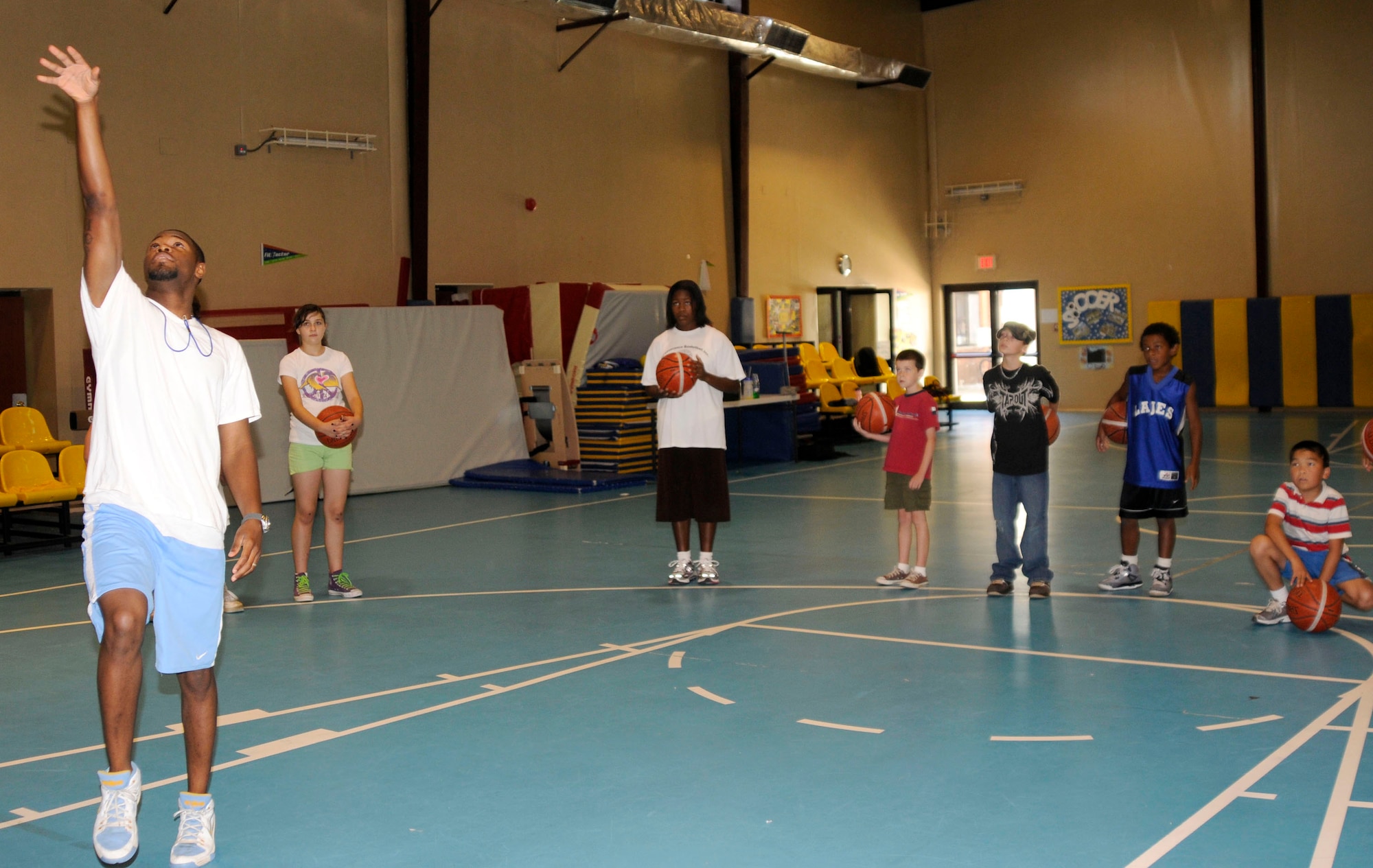 Basketball players watch as Tim Visor, Youth Programs assistant, demonstrates how to shoot a lay-up Tuesday, July 1, 2009 during a basketball camp at Incirlik Air Base, Turkey. The camp, which ran the entire week, is one of several camps and recreation trips available for children during their summer. For more information about activities call YP at 676-6670. (U.S. Air Force photo/Airman 1st Class Amber Russell)