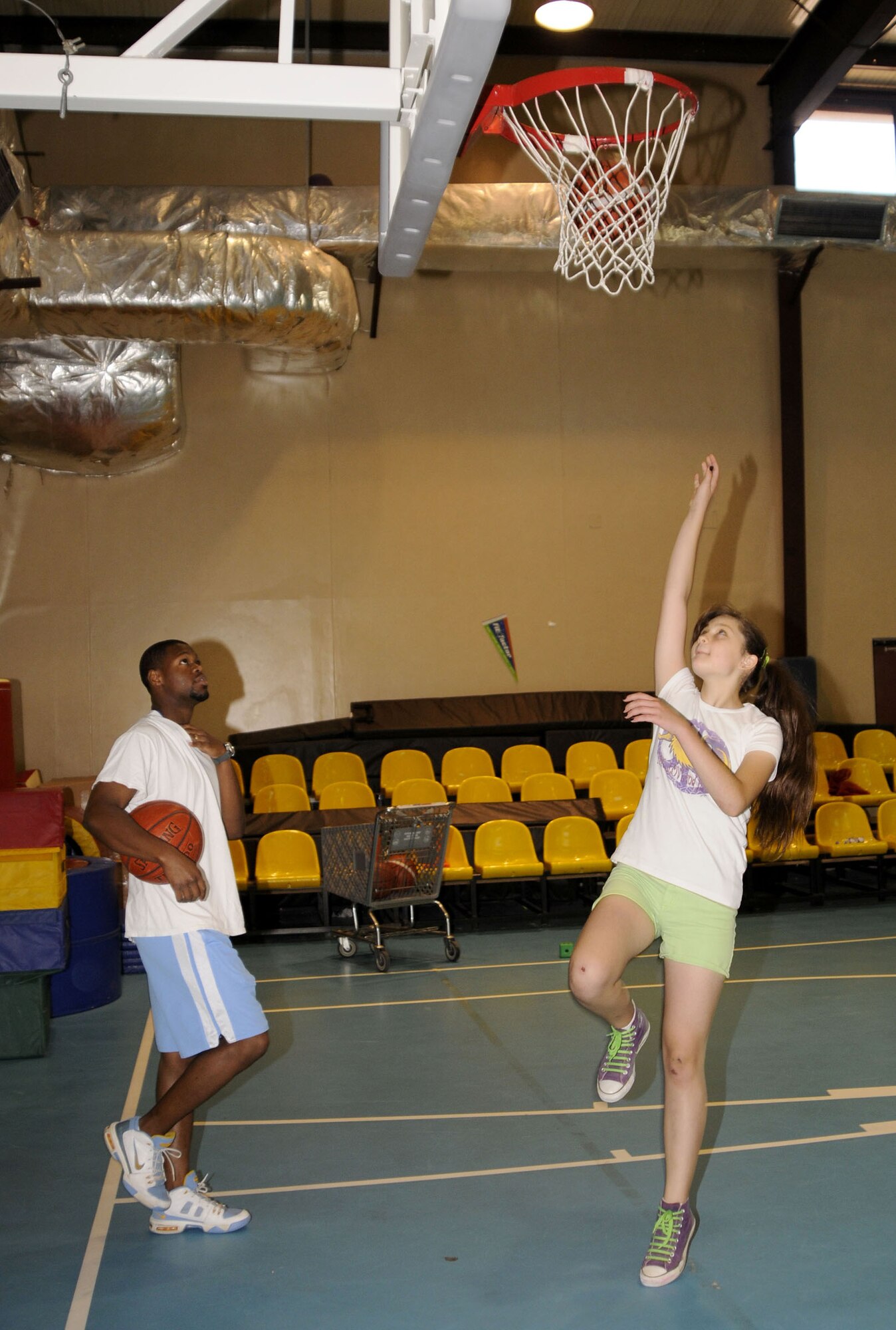 Tim Visor, Youth Programs assistant, watches as Katie Kaya, daughter of Elizabeth Kaya, 39th Communications Squadron, practices her lay-up Tuesday, July 1, 2009 during a basketball camp at Incirlik Air Base, Turkey. The camp, which ran the entire week, is one of several camps and recreation trips available for children during their summer. For more information about activities call YP at 676-6670. (U.S. Air Force photo/Airman 1st Class Amber Russell)