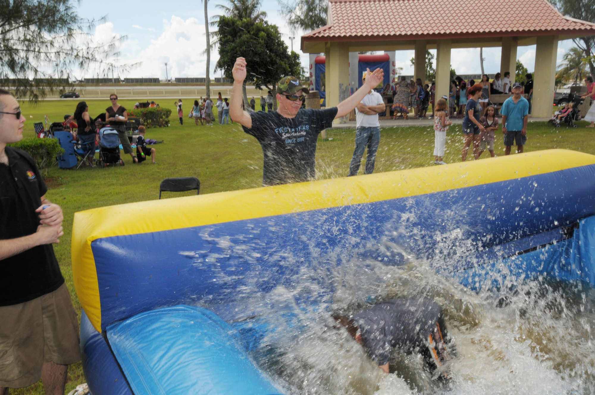 ANDERSEN AIR FORCE BASE, Guam - Senior Airman Jeffery Garcia enjoys a cooling spray of water thoughtfully provided by Brandon Martin during Andersen's Freedom Fest 2009 here July 2. Airman Garcia, here on temporary duty status from Buckley Air Force Base, Colo., assisted the Andersen Services personnel in running events.. Entertainment included live music, face painting, horse rides, a bouncy castle, a dunking booth, paintball, pie eating contests. (U.S. Air Force photo by Tech. Sgt. Michael Boquette)