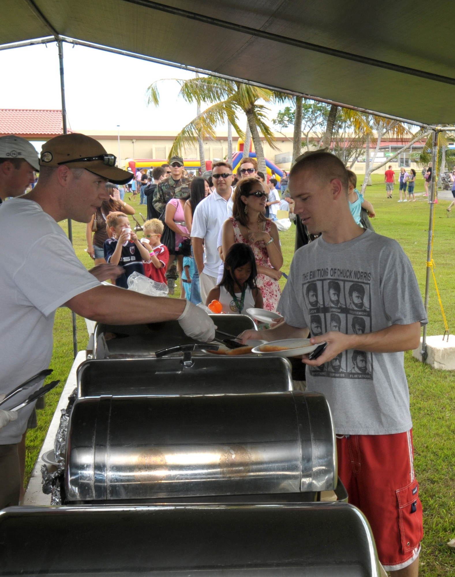 ANDERSEN AIR FORCE BASE, Guam  Staff Sgt. Timothy Milton, Buckley Air Force Base, Colo., serves up free burgers to Tech Sgt. Jason Trickey, 36th Operations Support Squadron, during Andersen's Freedom Fest 2009 here July 2. Other entertainment included live music, horse rides, face painting, a water slide, a bouncy castle, a dunking booth, paintball and pie eating contests. (U.S. Air Force photo by Tech. Sgt. Michael Boquette)