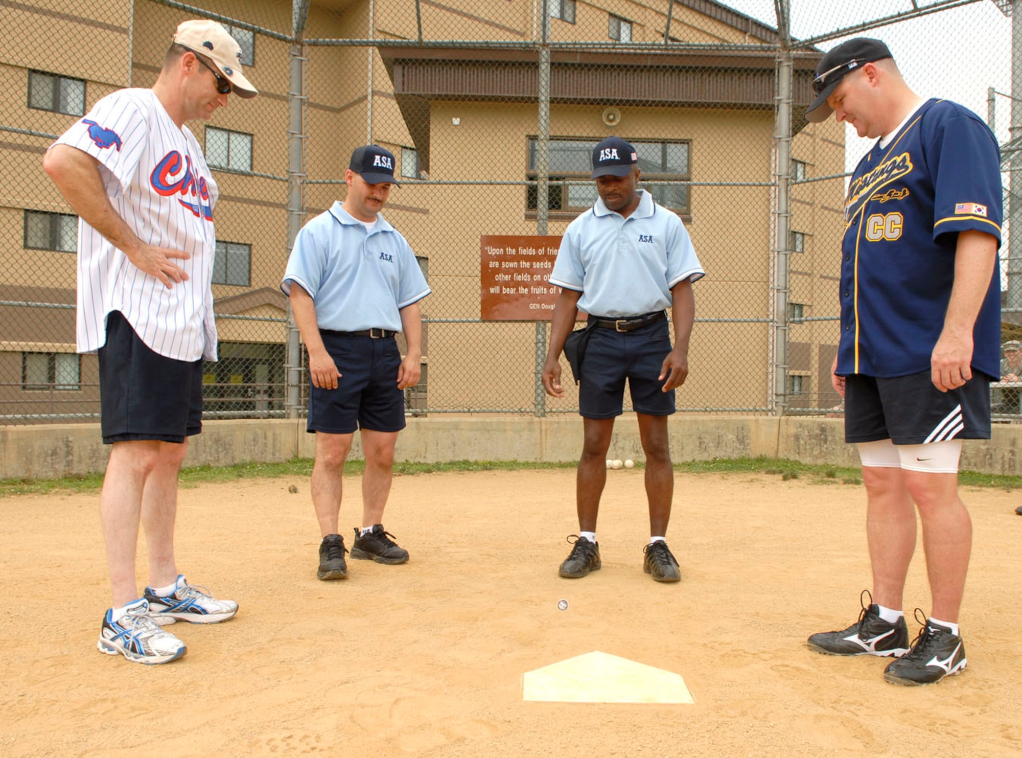 Chief Master Sgt. Darren Dwyer, (left) and Col. Thomas Deale, (right), anxiously wait for the coin to drop at the beginning of the annual Chiefs vs. Eagles softball tournement July 1 at Osan Air Base, Republic of Korea. Chief Master Sgt. Dwyer is the 51st Fighter Wing command chief and Colonel Deale is the 51st Fighter Wing commander. (U.S. Photograph by Senior Airman Stephenie Wade)