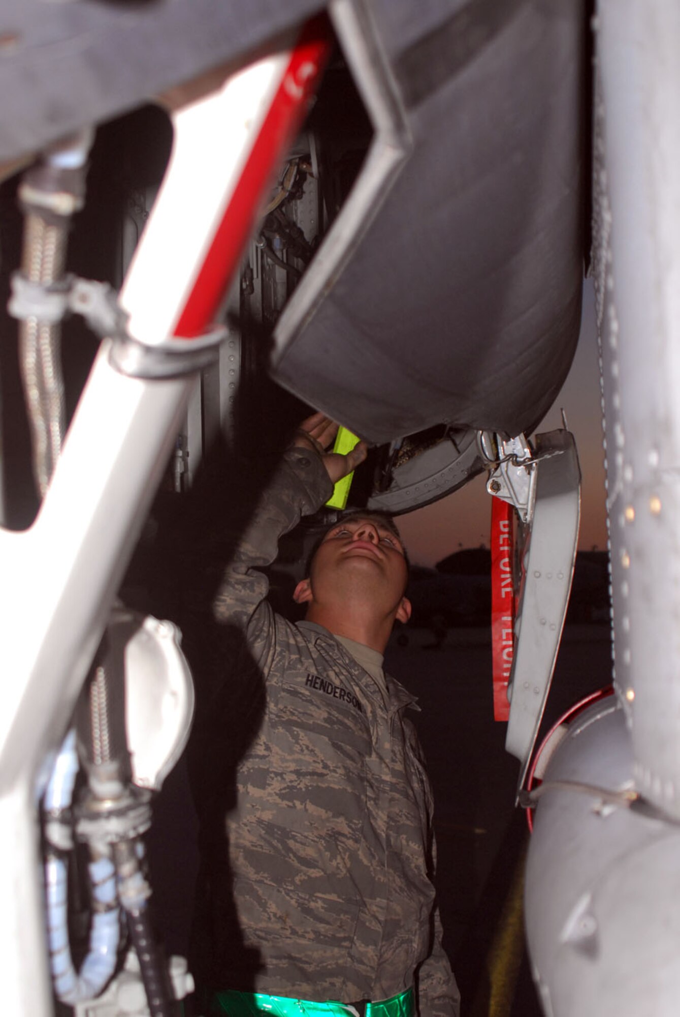 Airman 1st Class Matthew Henderson, 25th Aircraft Maintenance Unit  assistant dedicated crew chief, uses a flashlight to check the nose wheel on an A-10 during a post-flight isnpection here June 23. (U.S. Air Force photo/Staff Sgt. Terri Barriere)