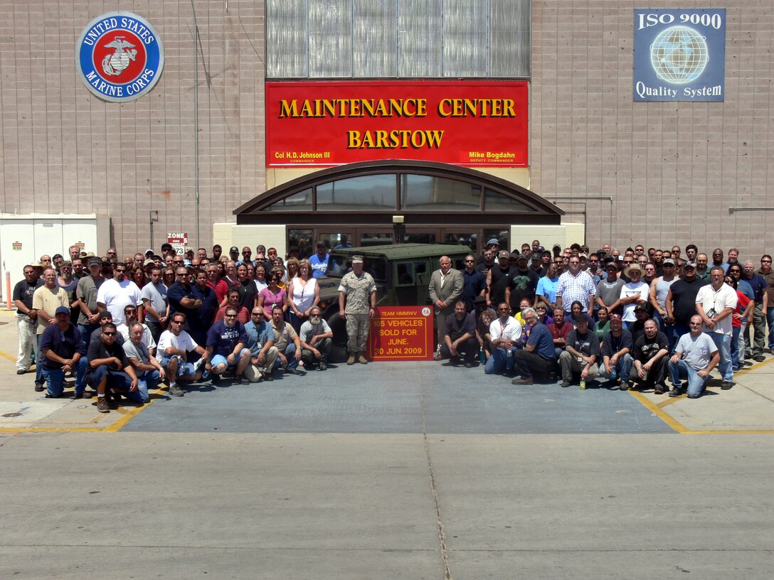 Maintenance Center Barstow, Marine Corps Logistics Base Barstow, Calif., Commanding Officer Col. Dale Johnson (left center), Deputy Commander Mike Bogdahn (right center) and Cost Work Center 717 Humvee Team workers stand next to the 105th High Mobility Multipurpose Wheeled Vehicle produced during June 2009. The workers at MCB have been able to mass-produce the Humvees using the assembly line process, which builds Humvees faster, for less cost.