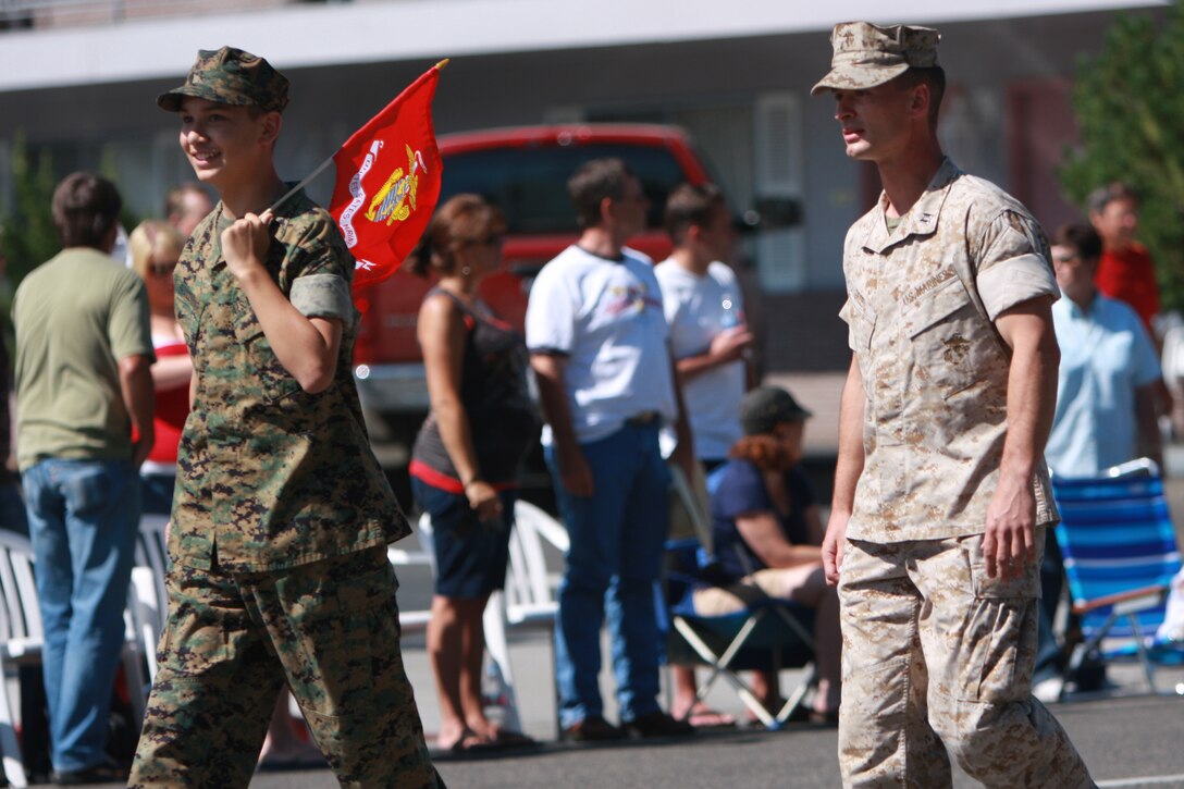 Alex Saldivar, a 14-year-old Bridgeport, Calif., native suffering from autism, bipolar disorder and attention deficit hyperactive disorder, struts his stuff with Capt. Matthew J. Green, the Mountain Warfare Training Center's communications officer, during Bridgeport's 147th Independence Day parade.