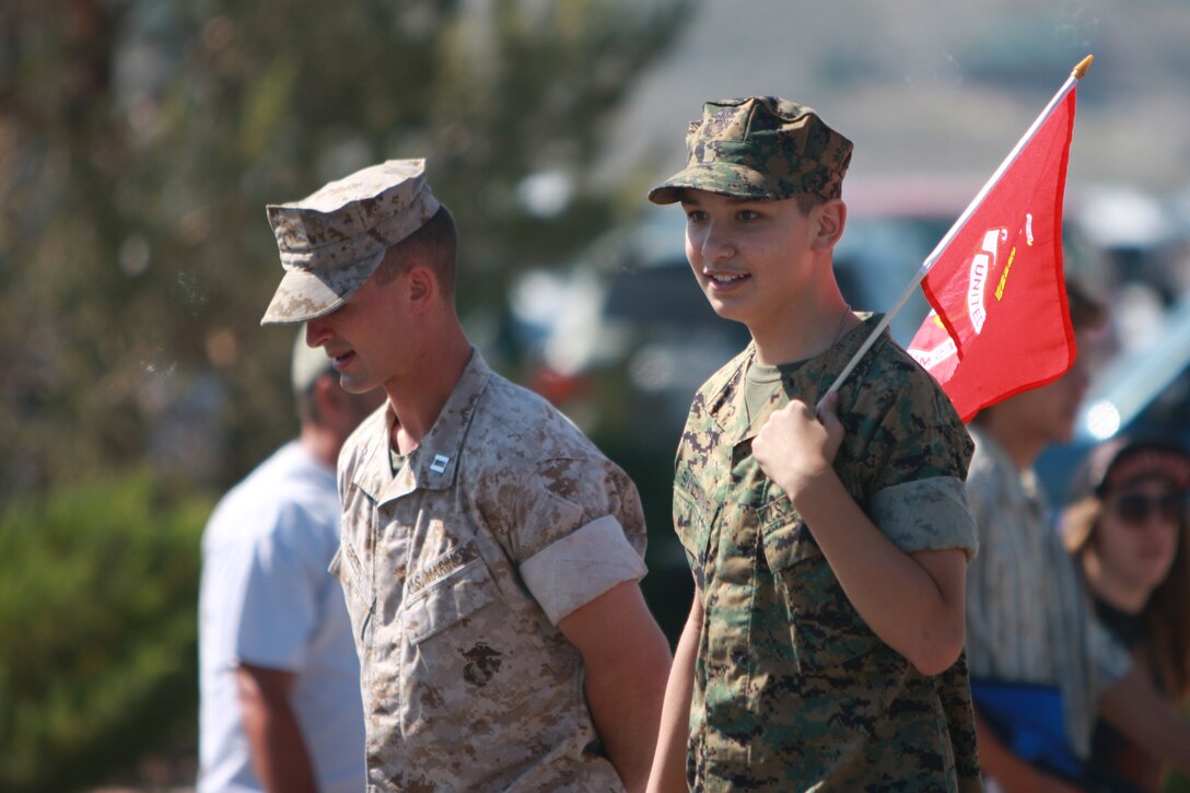Capt. Matthew J. Green, the Mountain Warfare Training Center's communications officer, walks alongside Alex Saldivar, a 14-year-old Bridgeport, Calif., native suffering from autism, bipolar disorder and attention deficit hyperactive disorder. The pair was a part of the Marine Corps' representation in Bridgeport's 147th Independence Day parade.