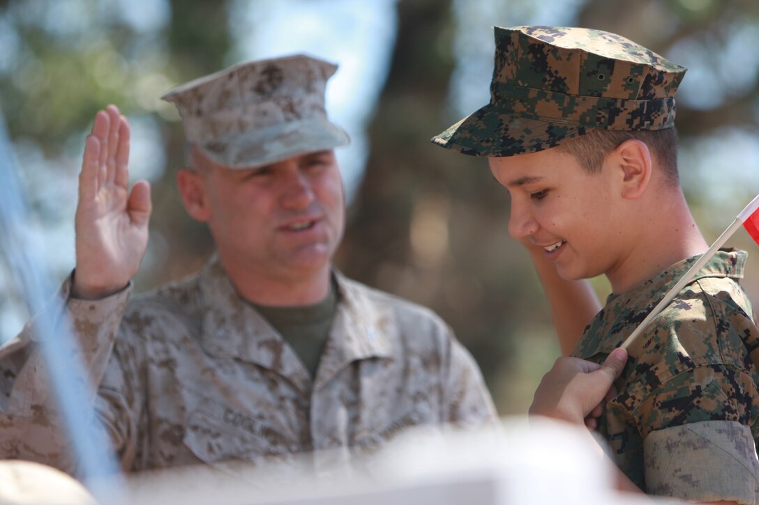 Alex Saldivar, a 14-year-old Bridgeport, Calif., native suffering from autism, bipolar disorder and attention deficit hyperactive disorder, is inducted into the Marine Corps team by Col. Norman J. Cooling, the commanding officer of the Mountain Warfare Training Center, during Bridgeport's 147th Independence Day parade. The Marines of MWTC granted Alex his life-long wish of standing side-by-side with the few and the proud at the parade.
