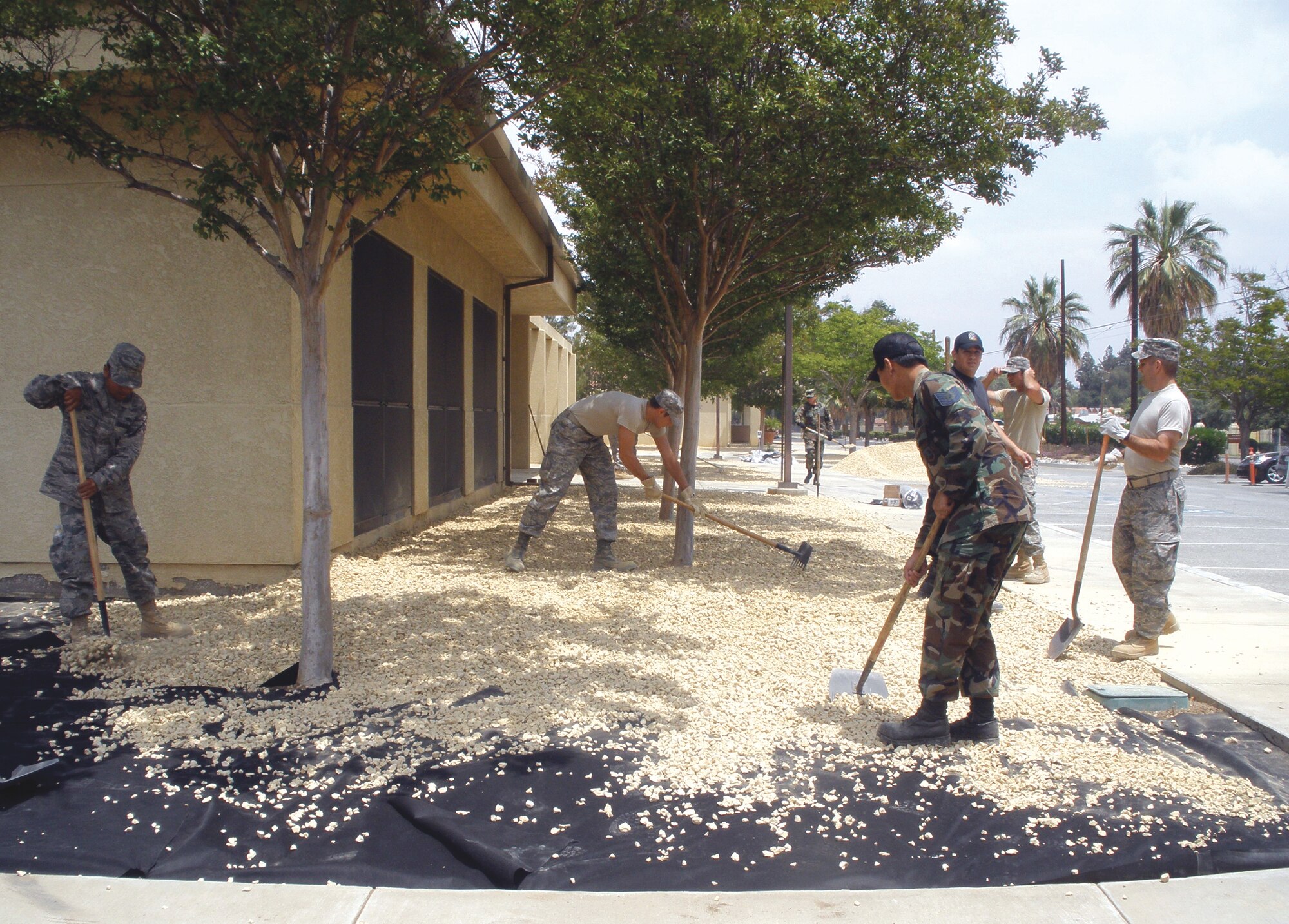 Staff from the Communications Squadron joined civil engineers removing plants and preparing the site to be covered with ‘California Gold’ rock. (U.S. Air Force photo by Ryan Wood)