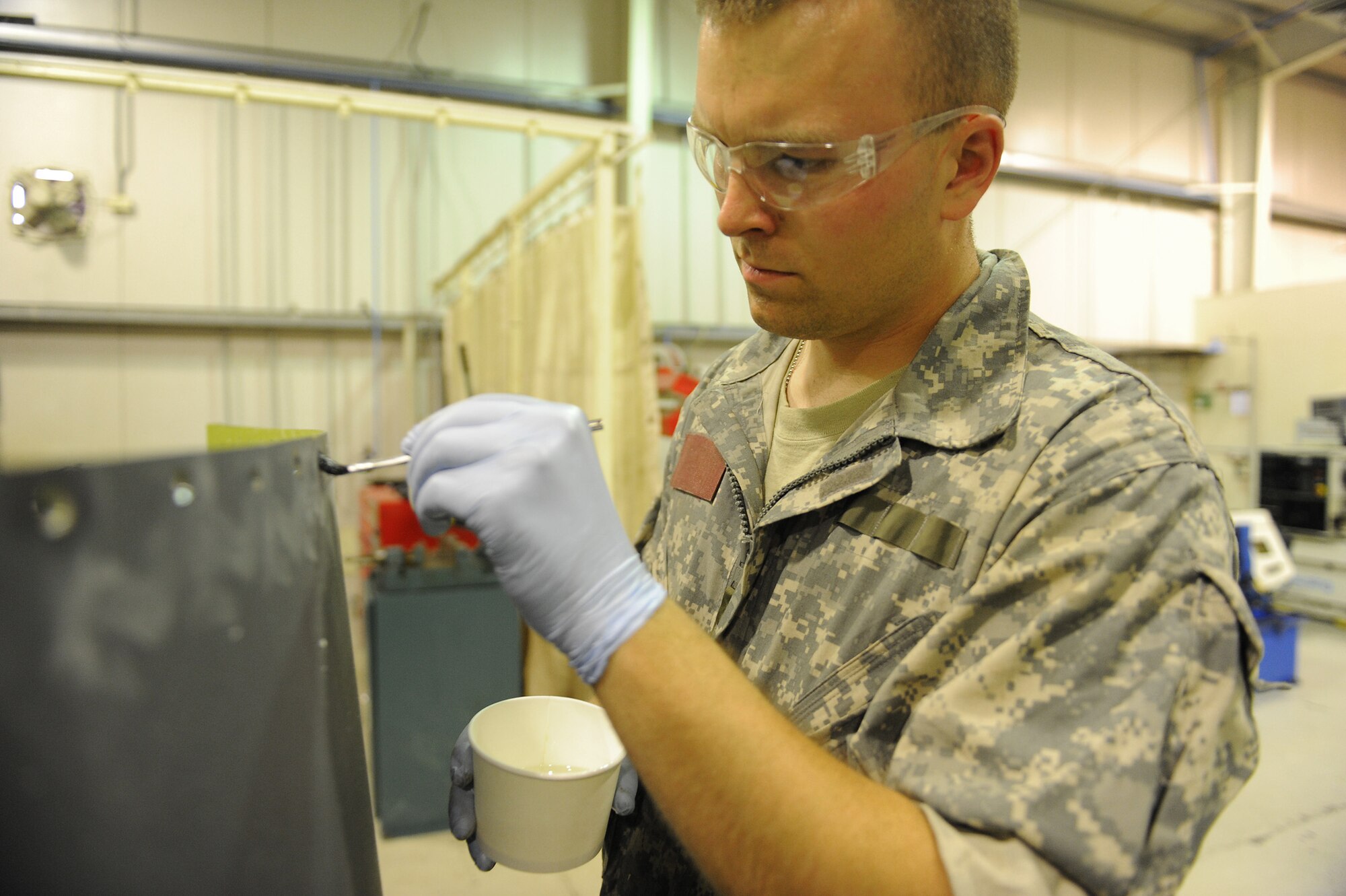 SOUTHWEST ASIA - Senior Airman Benjamin Evans, a 380th Expeditionary Maintenance Squadron, aircraft structural maintenance craftsman, puts a resin coating onto recently drilled counter sink holes on a panel for a KC-10 Extender, June 17 at an undisclosed location in Southwest Asia. The resin will provide a sealant to the holes keeping moisture from rusting the interior of the panel. (U.S. Air Force photo by Senior Airman Brian J. Ellis) (Released)