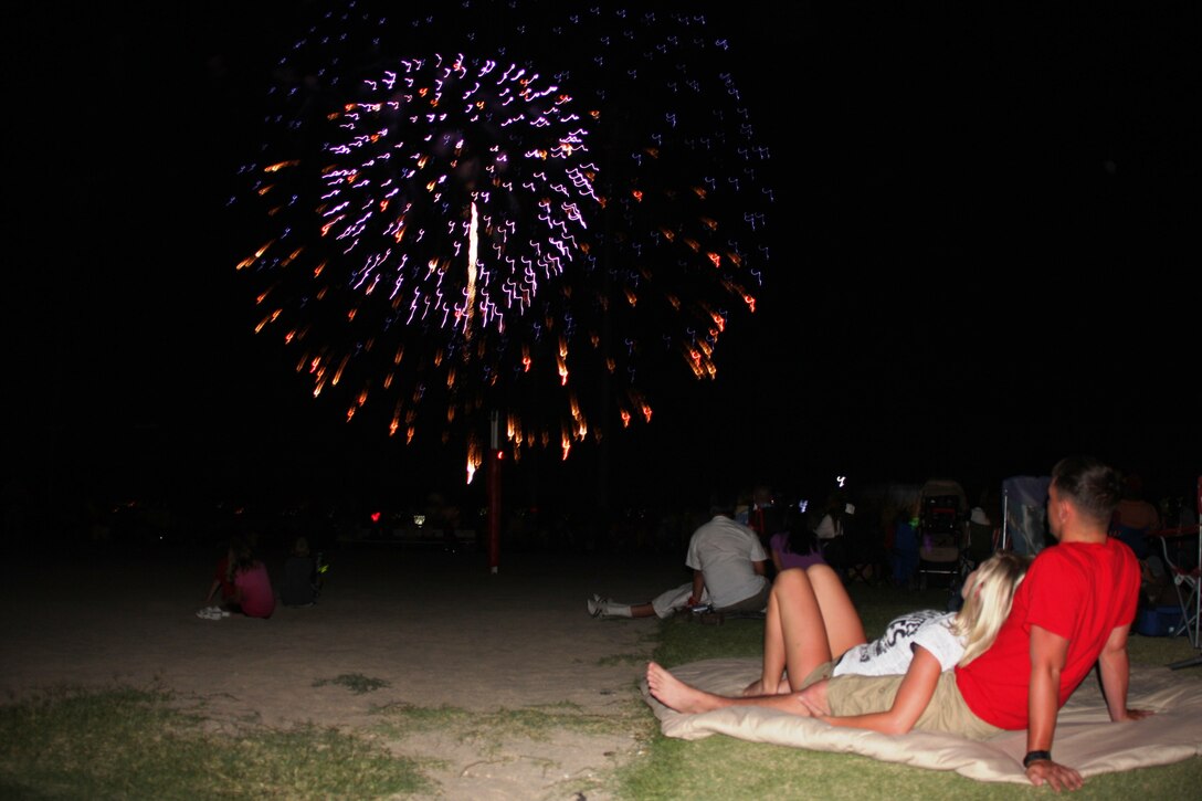 Lance Cpl. Jerrod Tisko, an unmanned aerial vehicle mechanic with Marine Unmanned Aerial Vehicle Squadron 3, watches the Morongo Basin's largest fireworks display with a friend at the Combat Center's Victory Field Saturday evening.