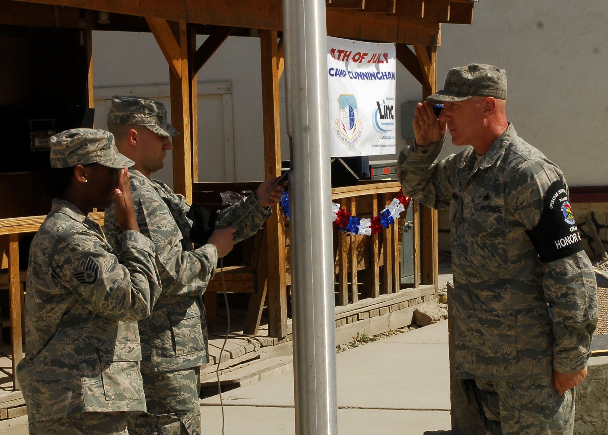 BAGRAM AIR FIELD, Afghanistan - Two Members of the Bagram Air Field Honor Guard salute as the American Flag is raised to commemorate the Fourth of July here. Bagram Air Field serves U.S. Air Forces Central and provides close air support, combat search rescue, aerial intelligence, surveillance and reconnaissance, and airlift capabilities to U.S. and coalition forces supporting Operation Enduring Freedom.(U.S. Air Force Photo by Senior Airman Felicia Juenke)