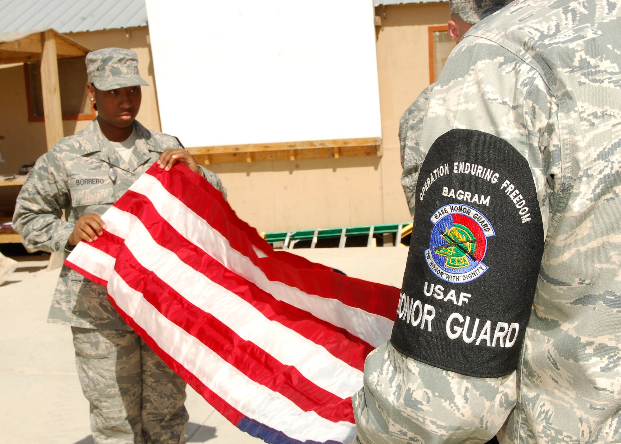 BAGRAM AIR FIELD, Afghanistan - 01.	Staff Sergeant Biagi Borrero,  455th Expeditionary Logistics Readiness Squadron, folds the American Flag with a fellow Bagram Air Field Honor Guard member during a flag raising event in order to commemorate the Fourth of July, here. SSgt Borrero hails from Hampton, Va., and is deployed from 366th Logistics Readiness Squadron based out of Mountain Home, Idaho.(U.S. Air Force Photo by Senior Airman Felicia Juenke)