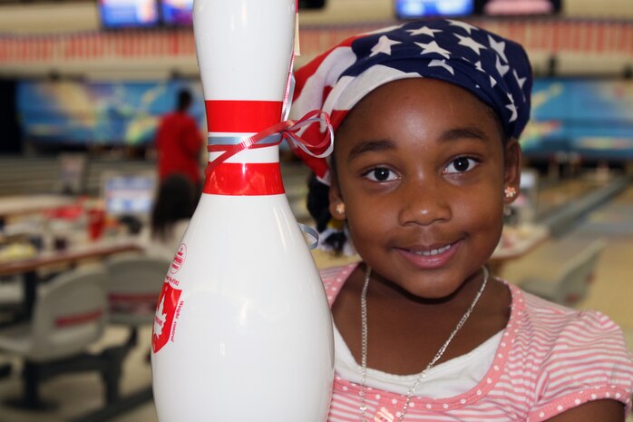 Raven Parker poses with her bowling pin after winning a free game  for bowling a strike during the first anniversary celebration of the Strike Zone's opening here July 4. The Strike Zone offered a variety of differnent bowling games along with tons of great deals, raffled off hourly prizes, and made sure everyone's first game of bowling was free.
