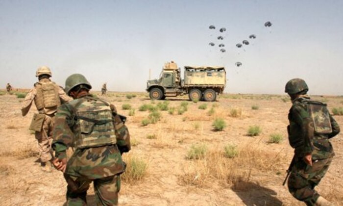 FIRE BASE FIDDLER GREEN, Helmand Province, Islamic Republic of Afghanistan -- Marines from 3rd Battalion, 11th Marines and soldiers from Afghan National Army rush back to their vehicles to pick up supplies from an air drop July 5 outside Fire Base Fiddler Green. A KC-130 dropped 12 pallets of fuel, food and water to support the personnel at the fire base.