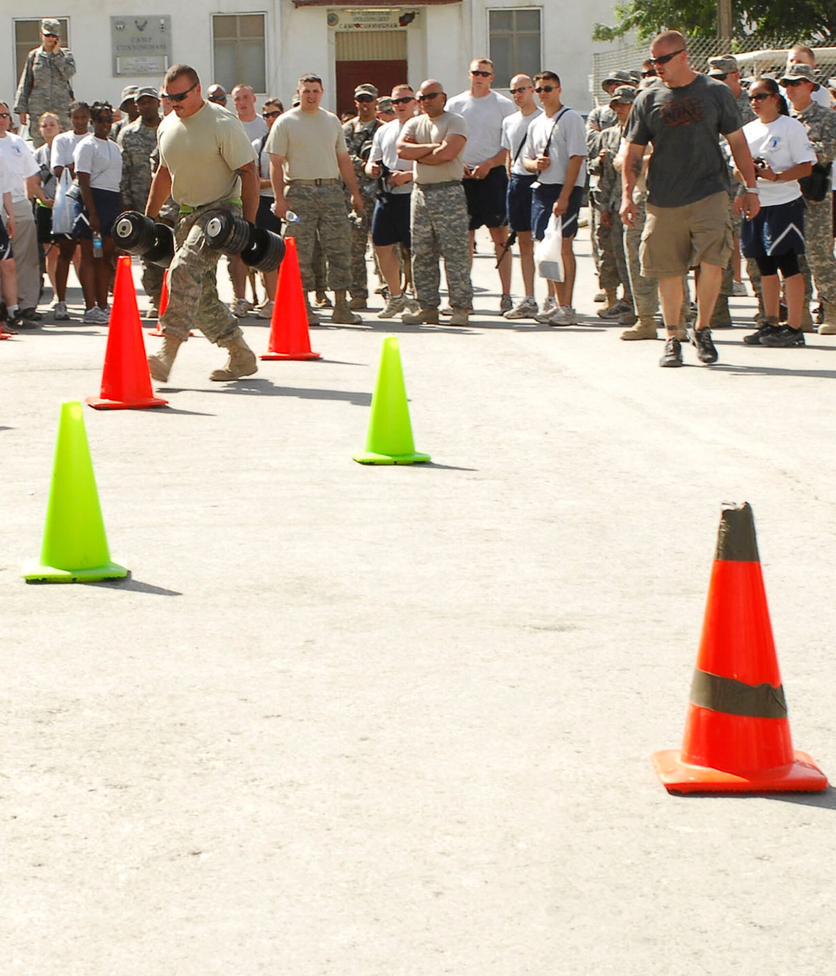 BAGRAM AIR FIELD, Afghanistan - Senior Airman Josh Berge, 455th Expeditionary Aircraft Maintenance Squadron, hurriedly carries weights to the finish line during The Strong Man Competition, here July 4. SrA Berge is a Helicopter Mechanic stationed out of Royal Air Force Lakenheath, England.(U.S. Air Force Photo by Senior Airman Felicia Juenke)