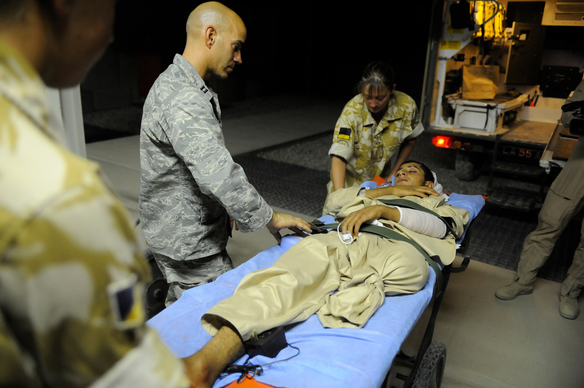 U.S. Air Force Capt. Jac Solghan, Aeromedical Evacuation Liaison Team flight clinical coordinator, comforts an Afghan boy who is returning home after weeks of care and rehabilitation by U.S. and Afghan medical personnel June 23, 2009, at Camp Bastion, Afghanistan. The boy lost his leg when a landmine exploded as he was walking along a road. (U.S. Air Force photo by Staff Sgt. Shawn Weismiller)