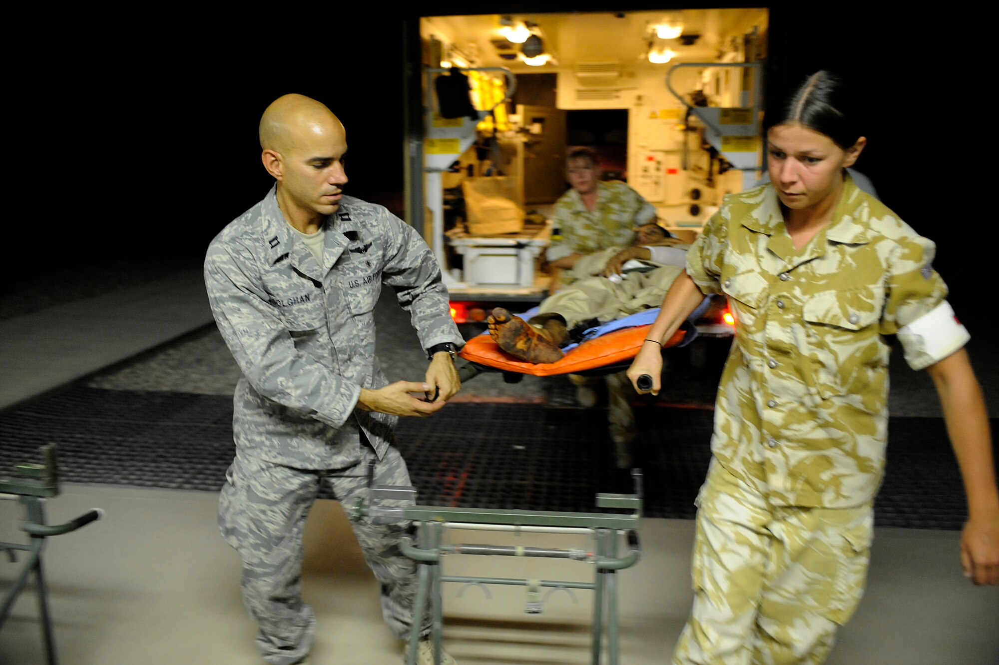 U.S. Air Force Capt. Jac Solghan, Aeromedical Evacuation Liaison Team flight clinical coordinator, and British Soldiers carry an Afghan boy who is returning home after weeks of care and rehabilitation by U.S. and Afghan medical personnel June 23, 2009, at Camp Bastion, Afghanistan. The boy lost his leg when a landmine exploded as he was walking along a road. (U.S. Air Force photo by Staff Sgt. Shawn Weismiller)