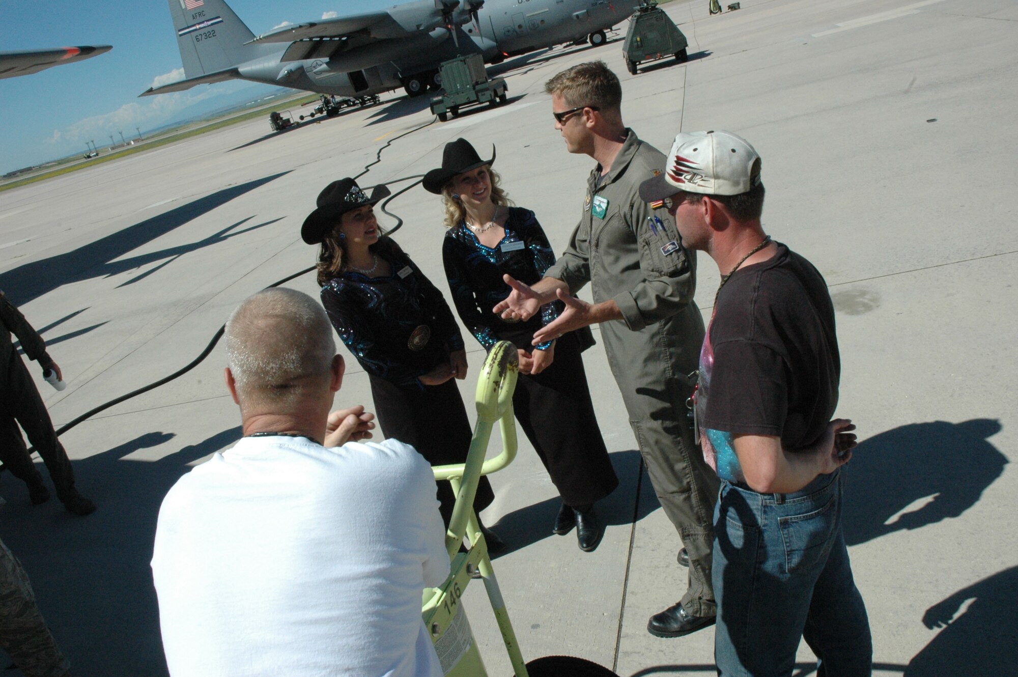 Maj. Michael Cole (center) describes for Girls of the West April Biernat (far left) and Aide Jessica Greene the capabilities of the C-130 "Hercules" tactical cargo aircraft  June 30 at Peterson Air Force Base, Colo. Major Cole, together with C-130 loadmasters Tech. Sgt. Jason Harvey and Airman 1st Class Nick Keith, escorted the Girls of the West onto Peterson's flightline, giving them an up-close look at the aircraft and the mission of the Air Force Reserve's 302nd Airlift Wing. The Girls of the West is a service-oriented organization, with an emphasis on horsemanship. (U.S. Air Force photo/Senior Airman Stephen J. Collier)