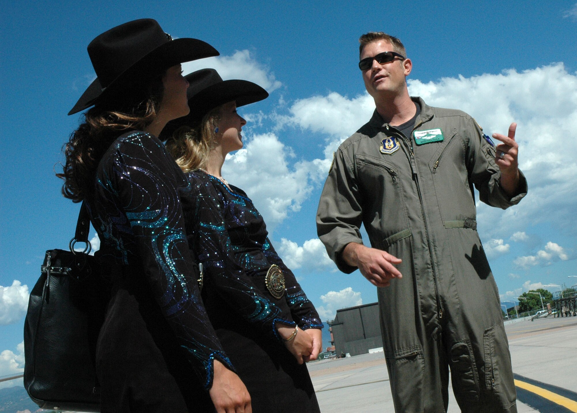 Maj. Michael Cole describes for Girls of the West April Biernat (left) and Aide Jessica Greene (center) the capabilities of the C-130 "Hercules" tactical cargo aircraft  June 30 at Peterson Air Force Base, Colo. Major Cole, together with C-130 loadmasters Tech. Sgt. Jason Harvey and Airman 1st Class Nick Keith, escorted the Girls of the West onto Peterson's flightline, giving them an up-close look at the aircraft and the mission of the Air Force Reserve's 302nd Airlift Wing. The Girls of the West is a service-oriented organization with an emphasis on horsemanship. (U.S. Air Force photo/Senior Airman Stephen J. Collier)