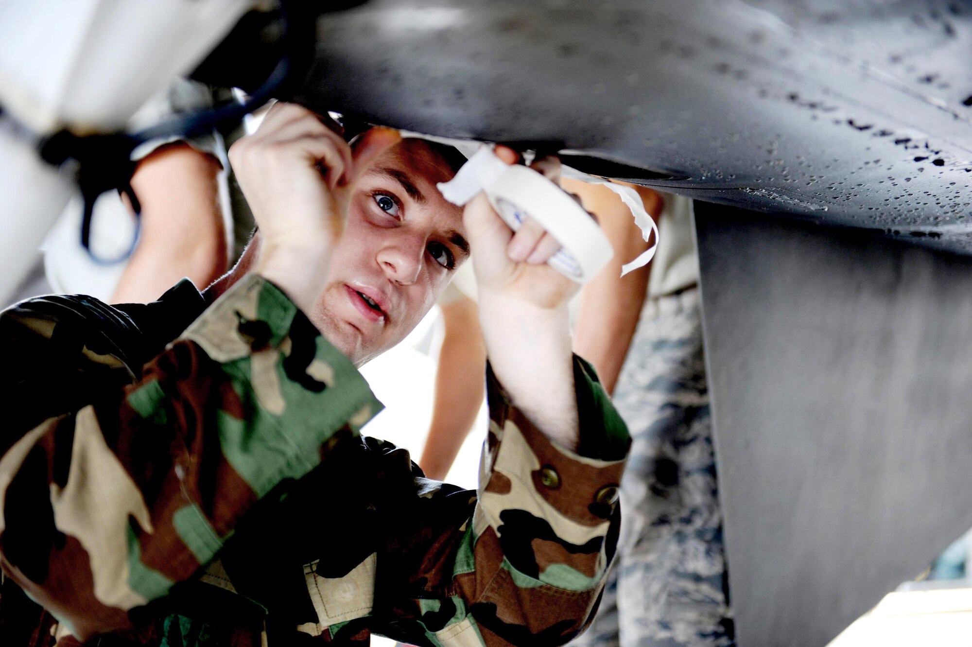 Airman 1st Class Dustin Fink tapes up a panel on an F-16 Fighting Falcon from the 79th Fighter Squadron at Shaw Air Force Base, S.C., prior to washing the aircraft.  Airmen from the 20th Maintenance Group were participating in an Air Force Smart Operations for the 21st Century rapid improvement event to enhance and improve wash rack operations for F-16 aircraft.  Airman Fink is an avionics system apprentice with the 79th FS.  (U.S. Air Force photo/Senior Airman Matt Davis)
