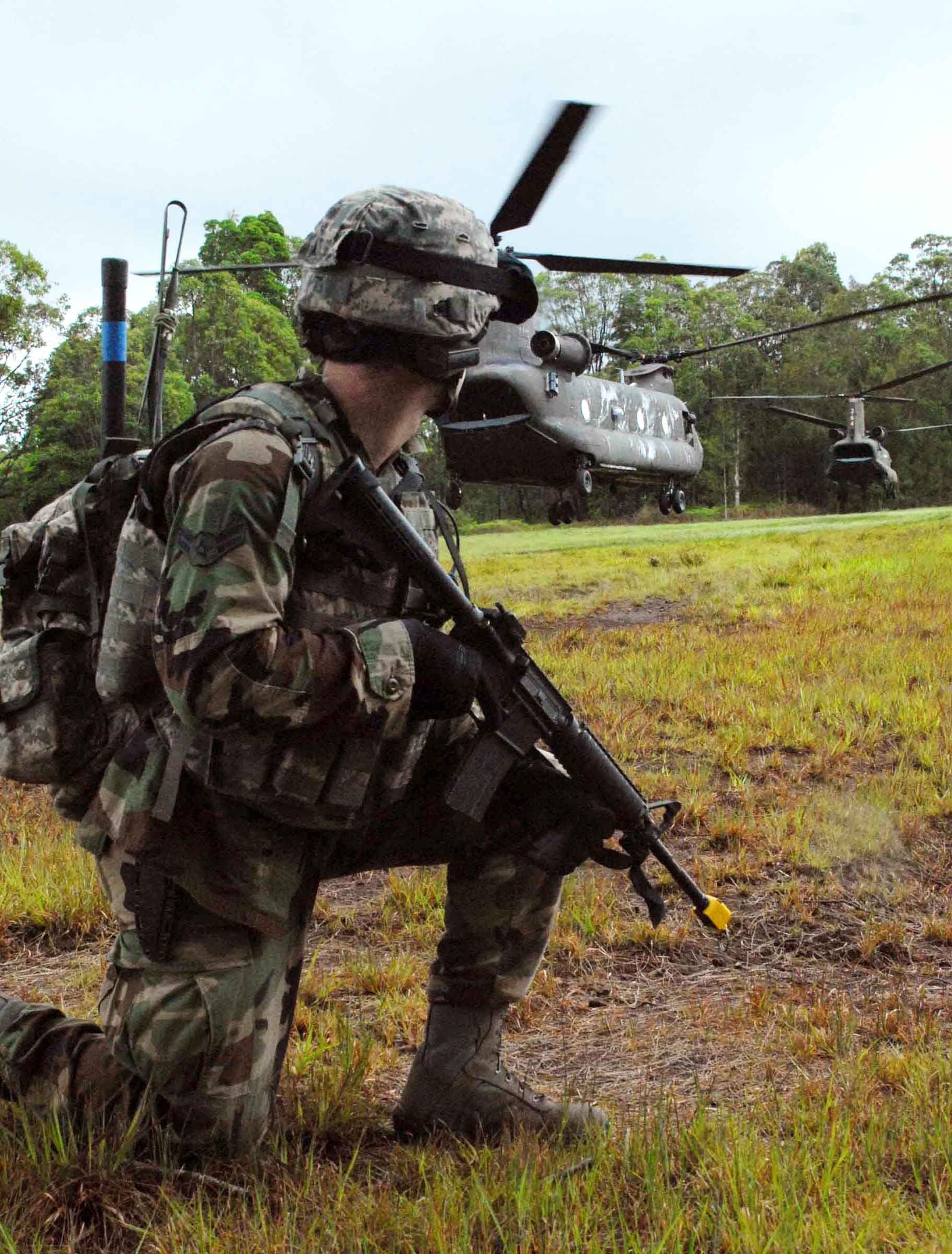 A 25th Air Support Operations Squadron tactical air control party Airman provides landing zone security for an Army National Guard CH-47 Chinook on Wheeler Army Airfield's East Range, Hawaii, June 23 near Hickam Air Force Base, Hawaii. He and other radio operators, maintainers and drivers camped out for four days to sharpen proficiencies necessary for upgrade training to become combat mission-ready joint terminal attack controllers. Because they're training now, they'll have a better idea of what to expect when they get to Afghanistan with an Army unit. (U.S. Air Force photo/Senior Airman Carolyn Viss) 