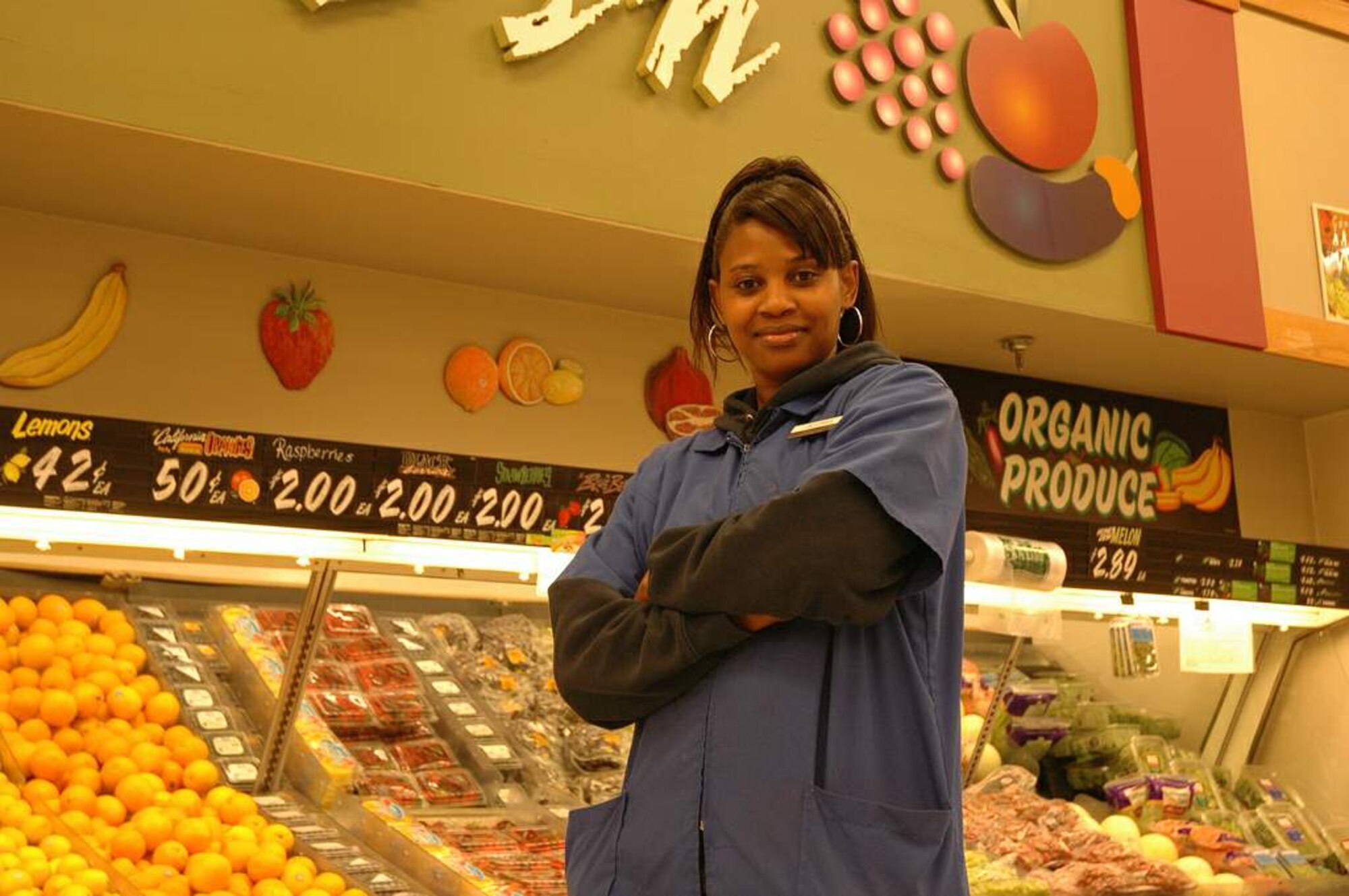 Josephine "Jo" Craig, a Defense Commissary Agency store associate, stands by a fully stocked vegetable display at the commissary on Fort Lee, Va. Ms. Craig is just one of DeCA's 18,000 employees who will be taking the Dale Carnegie Training on World Class Customer Service. (DeCA photo/Millie Slamin) 

