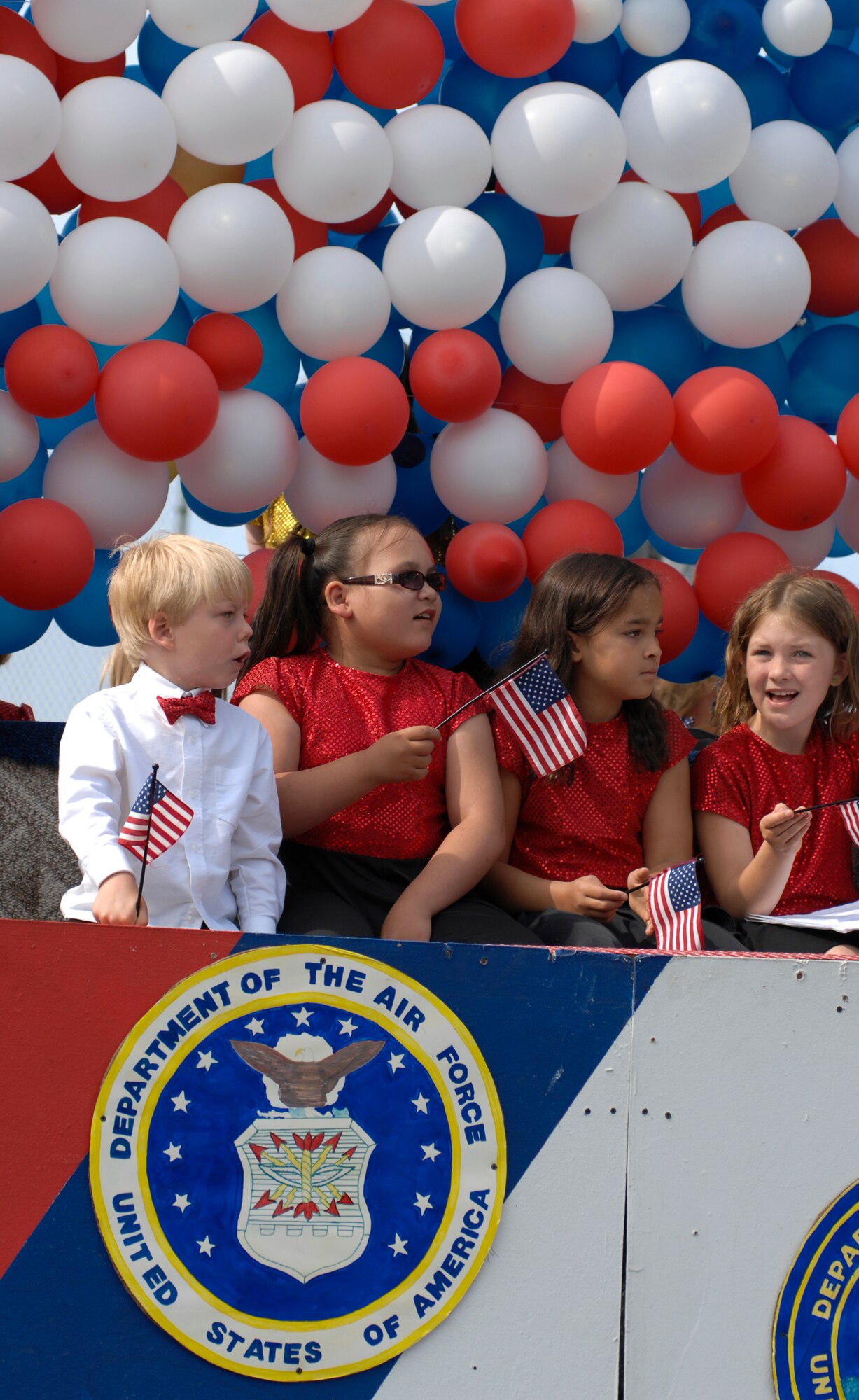 ANCHORAGE, Alaska -- Children hold flags as they ride on a military appreciation float during the Fourth of July Parade here. (U.S. Air Force photo/Senior Airman David Carbajal)
