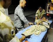 Capt. Jac Solghan comforts an Afghan boy who is returning home after weeks of care and rehabilitation by U.S. and Afghan medical personnel June 23 at Camp Bastion, Afghanistan. The boy lost his leg when a landmine exploded as he was walking along a road. Captain Solghan is the Aeromedical Evacuation Liaison Team flight clinical coordinator. (U.S. Air Force photo/Staff Sgt. Shawn Weismiller)