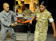 Capt. Jac Solghan and British Soldiers carry an Afghan boy who is returning home after weeks of care and rehabilitation by U.S. and Afghan medical personnel June 23 at Camp Bastion, Afghanistan. The boy lost his leg when a landmine exploded as he was walking along a road. Captain Solghan is the Aeromedical Evacuation Liaison Team flight clinical coordinator. (U.S. Air Force photo/Staff Sgt. Shawn Weismiller)