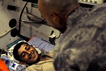 Capt. Jac Solghan comforts an Afghan boy who is returning home after weeks of care and rehabilitation by U.S. and Afghan medical personnel June 23 at Camp Bastion, Afghanistan. The boy lost his leg when a landmine exploded as he was walking along a road. Captain Solghan is the Aeromedical Evacuation Liaison Team flight clinical coordinator. (U.S. Air Force photo/Staff Sgt. Shawn Weismiller)