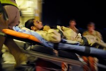 Military personnel assigned to the aeromedical evacuation liaison team carry an Afghan boy who is returning home after weeks of care and rehabilitation by U.S. and Afghan medical personnel June 23 at Camp Bastion, Afghanistan. The boy lost his leg when a landmine exploded as he was walking along a road. (U.S. Air Force photo/Staff Sgt. Shawn Weismiller) 