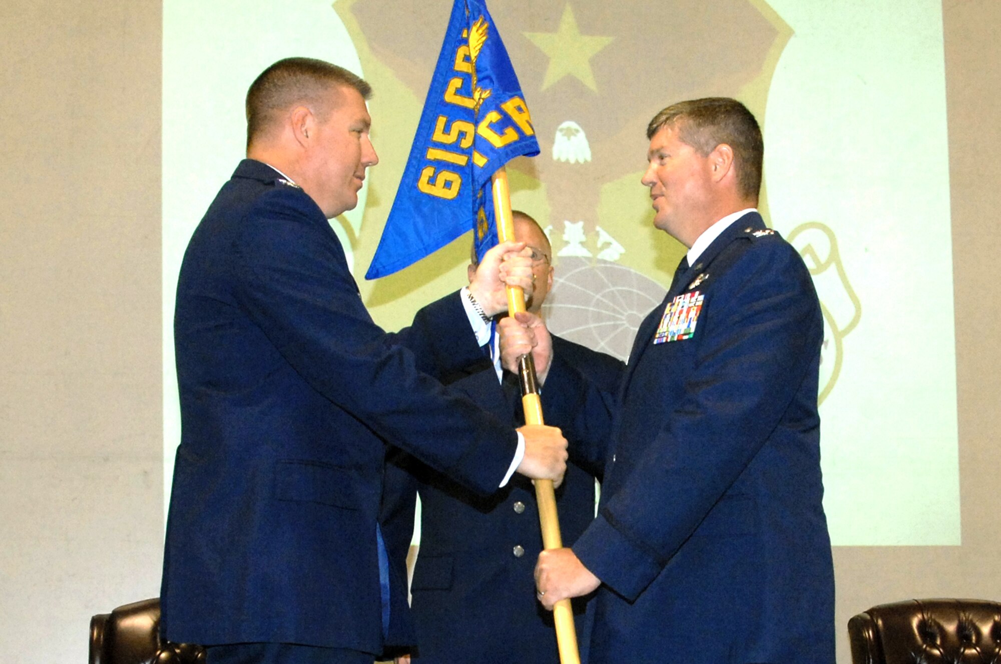 Col. John Lipinski, left, 615th Contingency Response Wing commander, hands the 571st  Contingency Response Group guideon to Col. Tracy "Red" Skelton during the 571st CRG change-of-command ceremony June 29. (U.S. Air Force photo/Nan Wylie)