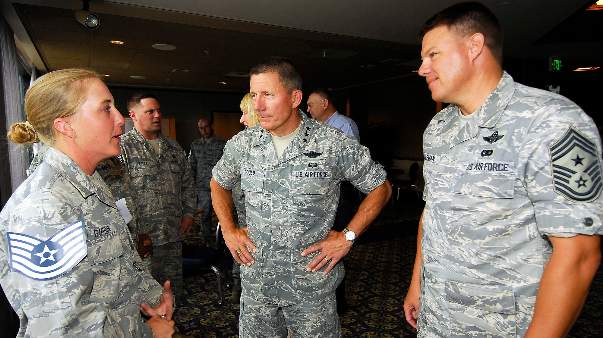 From right, Chief Master Sgt. Todd Salzman and Lt. Gen. Michael Gould congratulate Staff Sgt. Johnnie Gipson at a technical sergeant promotion party at the U.S. Air Force Academy, Colo., June 26. General Gould is the Academy superintendent; Chief Salzman is the Academy command chief. (U.S. Air Force photo/Rachel Boettcher)