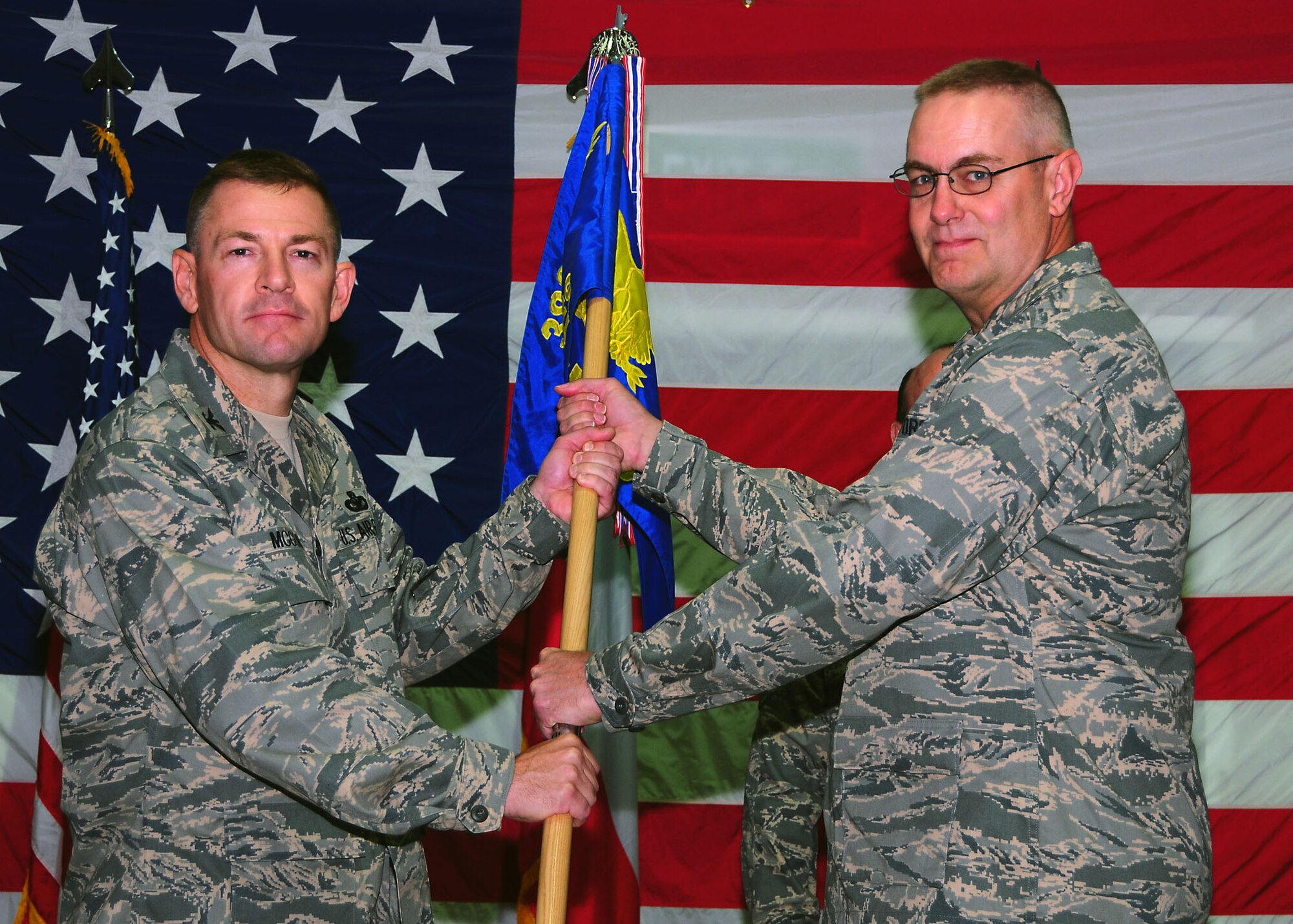 Lt. Col. Matthew Bobb assumes command of the 386th Expeditionary Civil Engineer Squadron, by accepting the guidon from Col. Richard McComb,  386th Expeditionary Mission Support Group commander, during a change of command ceremony in Southwest Asia July 6.  (U.S. Air Force photo/Senior Airman Courtney Richardson)