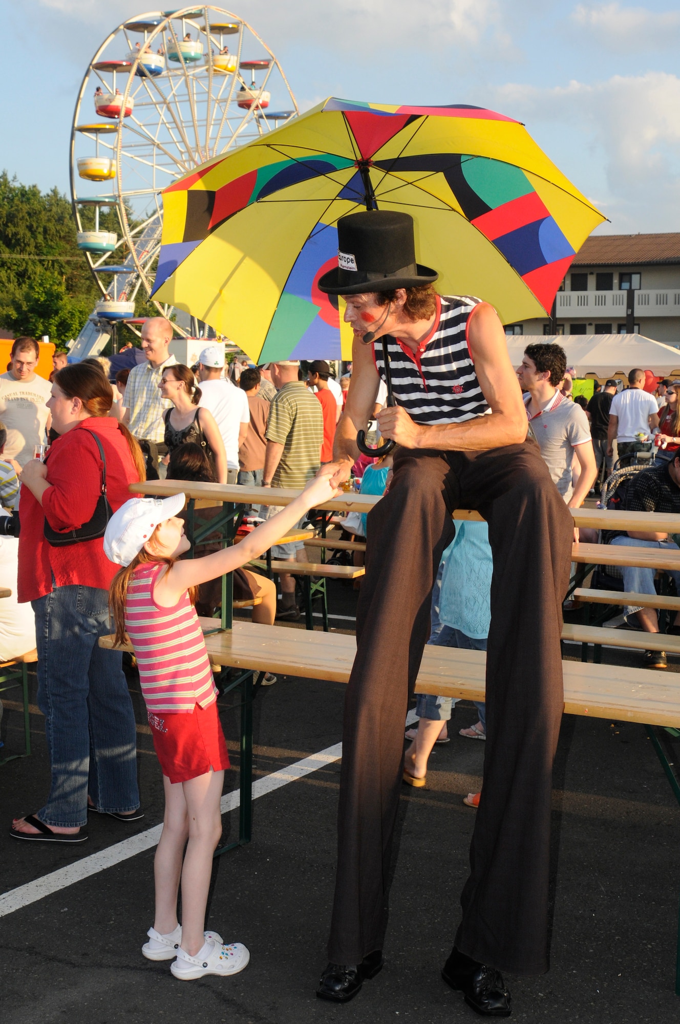 Clown Eilou (right) shakes hands with Breanna Dryden,9, July 4, 2009, Kapaun Air Station, Germany. Kaiserslautern Military Community members celebrated the Rockin’ Fourth of July event with games, rides and concerts and ended the night with fireworks. (U.S. Air Force photo by Tech. Sgt. Kenneth Bellard)