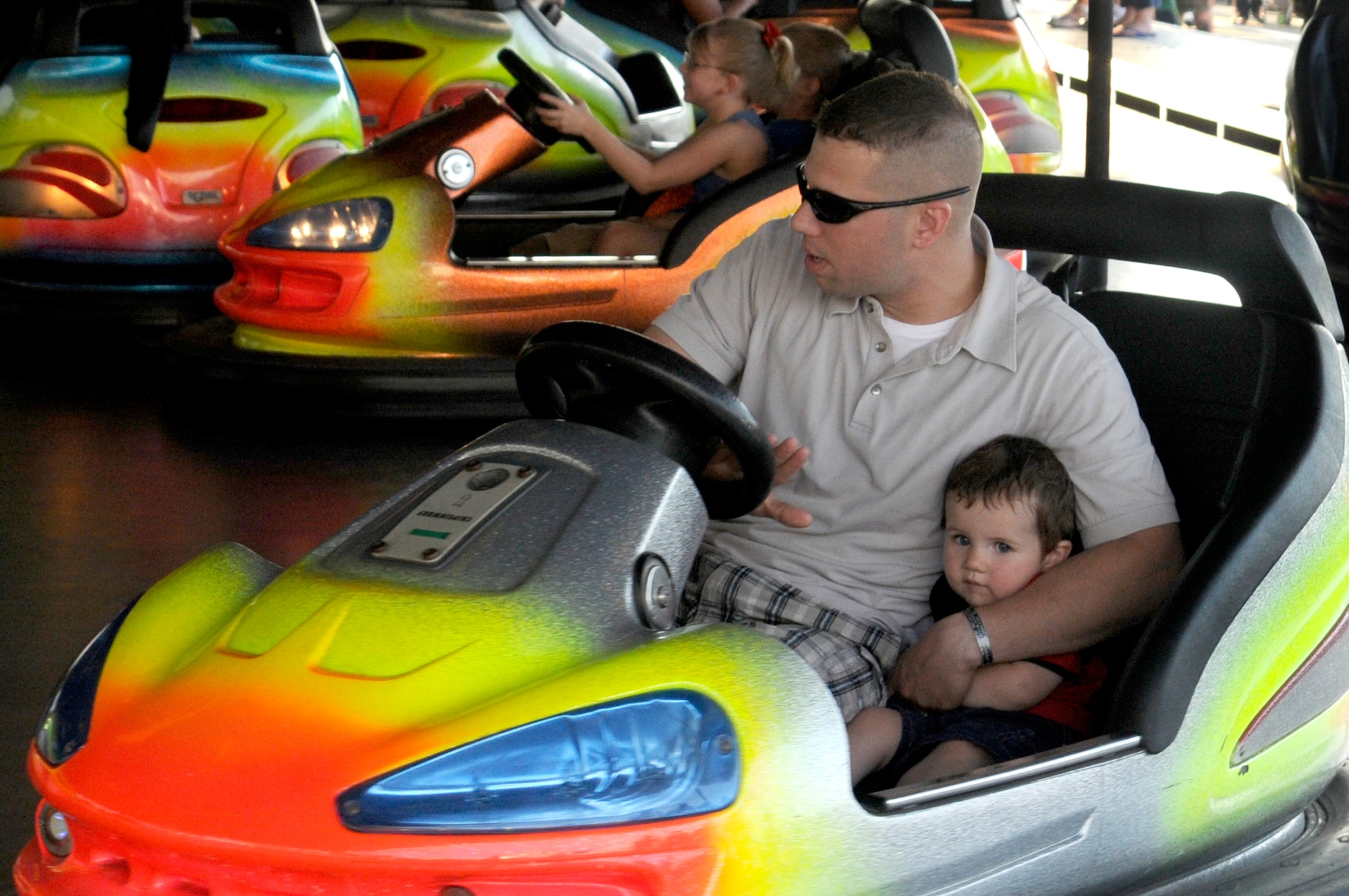 U.S. Army Staff Sgt. Dan Lazinek (left), 1st Armored Division 1st Battalion 6th Infantry regiment, Baumholder, Germany,  embraces son, Zachery, 1, before hitting another bumper car, July 4, 2009, Kapaun Air Station, Germany. Kaiserslautern Military Community members celebrated the Rockin’ Fourth of July event with games, rides and concerts and ended the night with fireworks. (U.S. Air Force photo by Tech. Sgt. Kenneth Bellard)