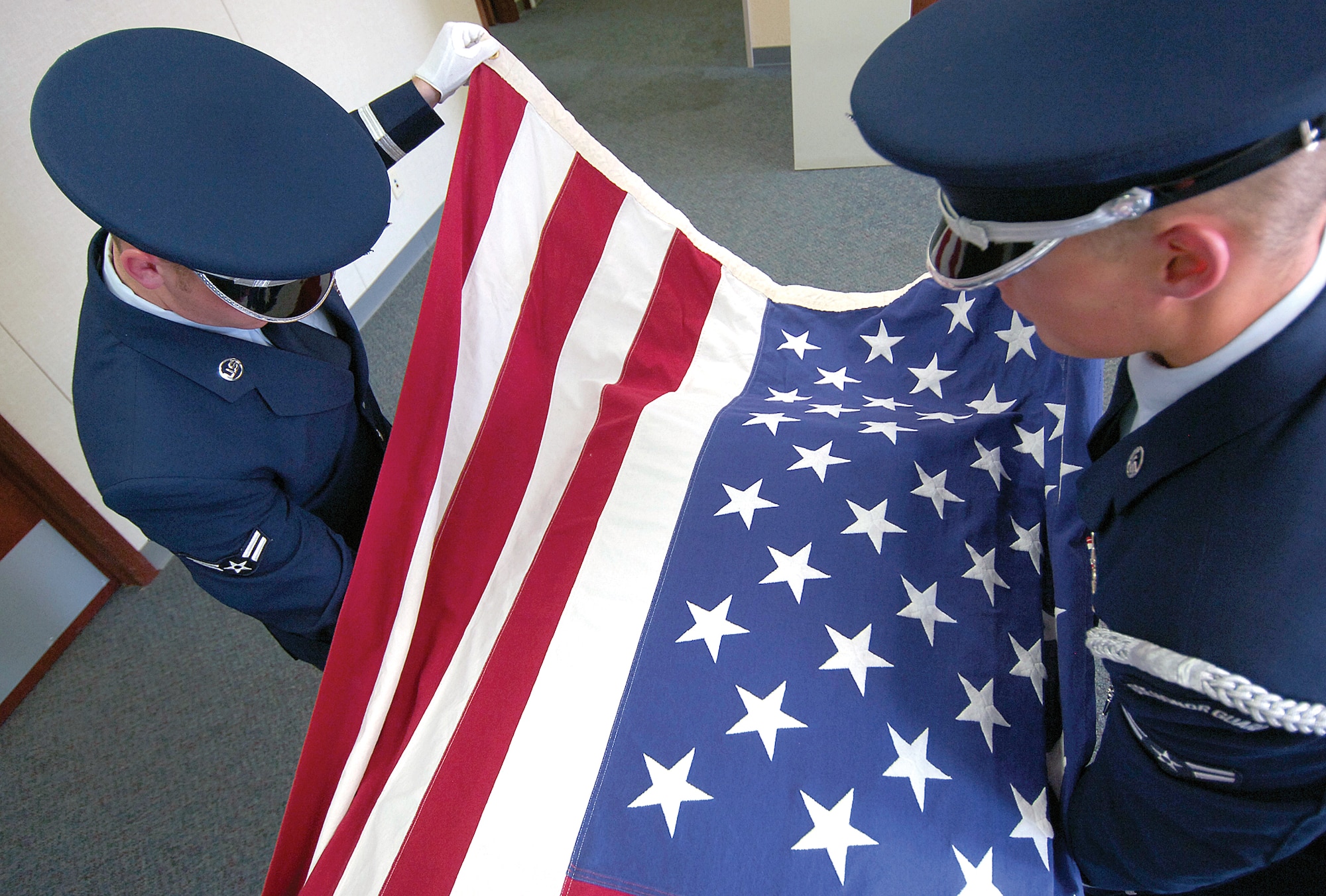 Tinker Honor Guard members regularly practice how to drape, remove and fold a flag from a casket. A training casket and flag in their Bldg. 244 office are reliable tools preparing them for actual funerals. (Air Force photo by Margo Wright)