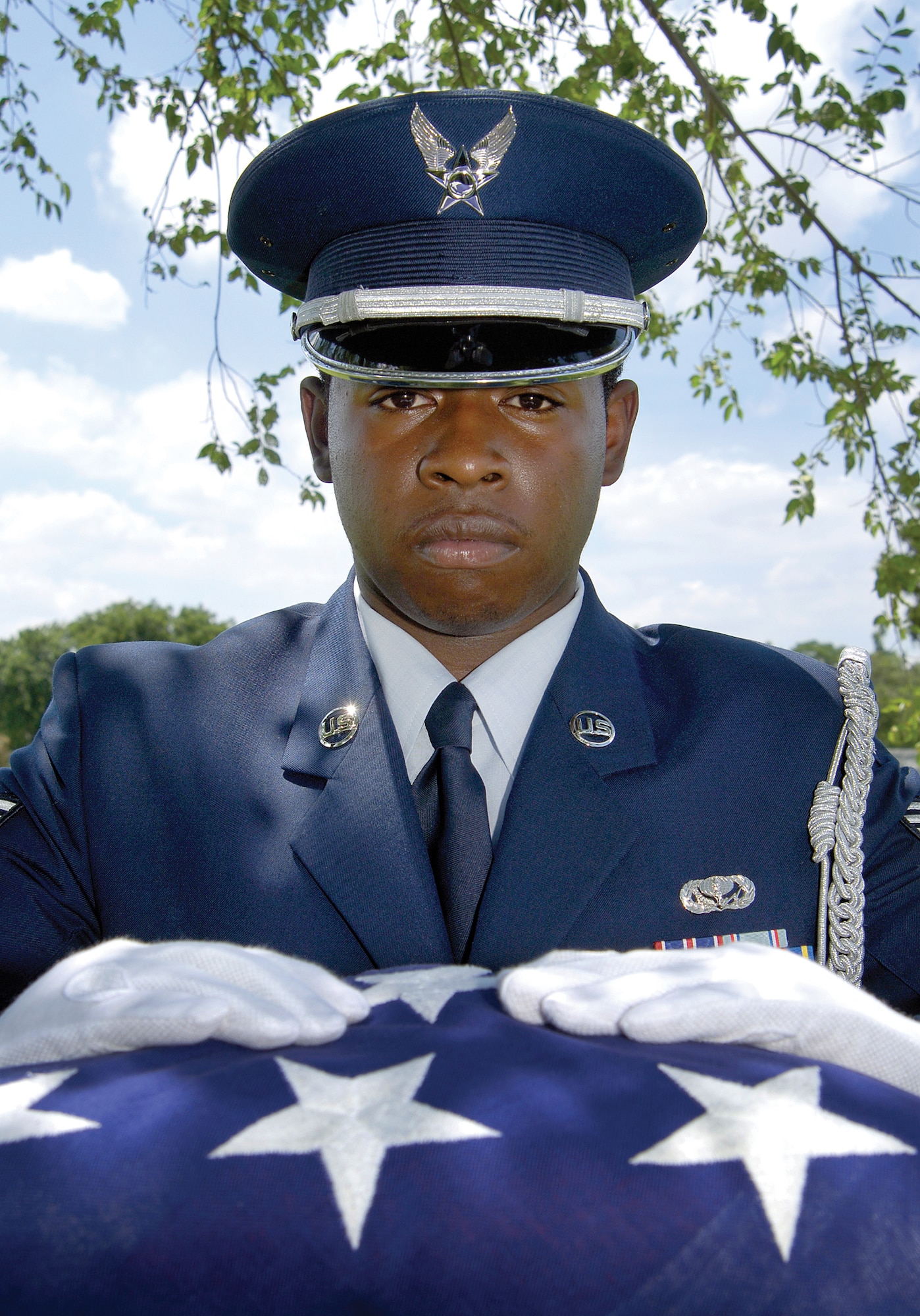 Tinker Air Force Base Honor Guard members represent the sympathies of a nation and her Air Force when honoring the service of a member during their funeral.  On bended knee and with the words, “On behalf of a grateful nation…” a folded flag is given to family members. Senior Airman Willie Hart practices here. (Air Force photo by Margo Wright)