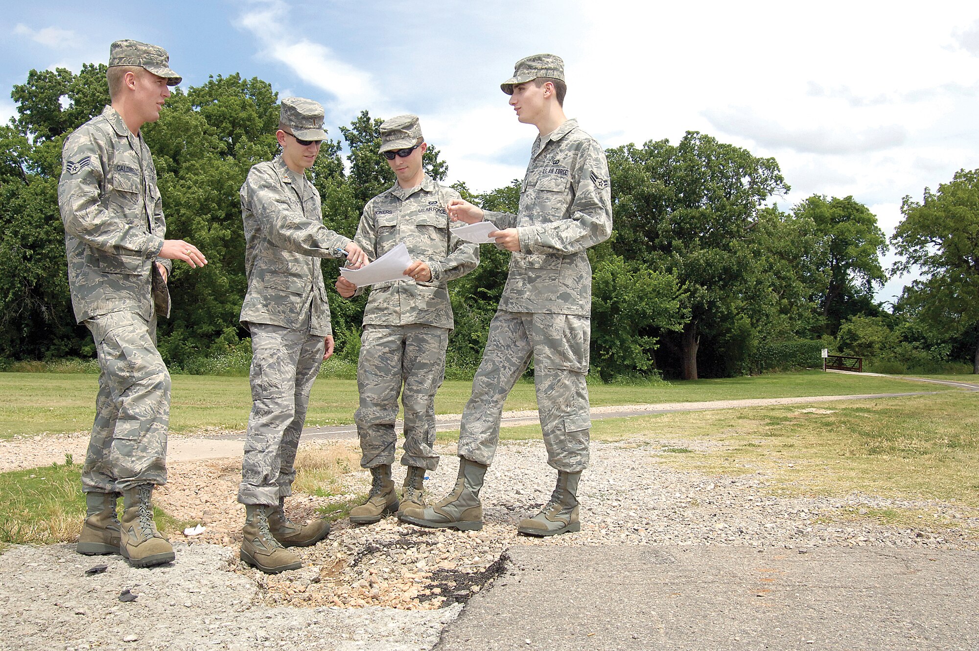 A VPP team discusses safety concerns about the Wildcatter Run path, looking for re-routing or re-engineering solutions to make it safer.  “We’re looking at ways to keep the 72nd Air Base Wing safer and not impact the mission,” says Senior Airman Scott Caldwell, left, standing with 2nd Lt. Philip Olson, Senior Airman Micha Vickers and Airman 1st Class Chad Manary. (Air Force photo by Margo Wright)