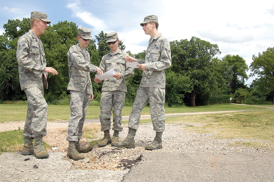 A VPP team discusses safety concerns about the Wildcatter Run path, looking for re-routing or re-engineering solutions to make it safer.  “We’re looking at ways to keep the 72nd Air Base Wing safer and not impact the mission,” says Senior Airman Scott Caldwell, left, standing with 2nd Lt. Philip Olson, Senior Airman Micha Vickers and Airman 1st Class Chad Manary. (Air Force photo by Margo Wright)