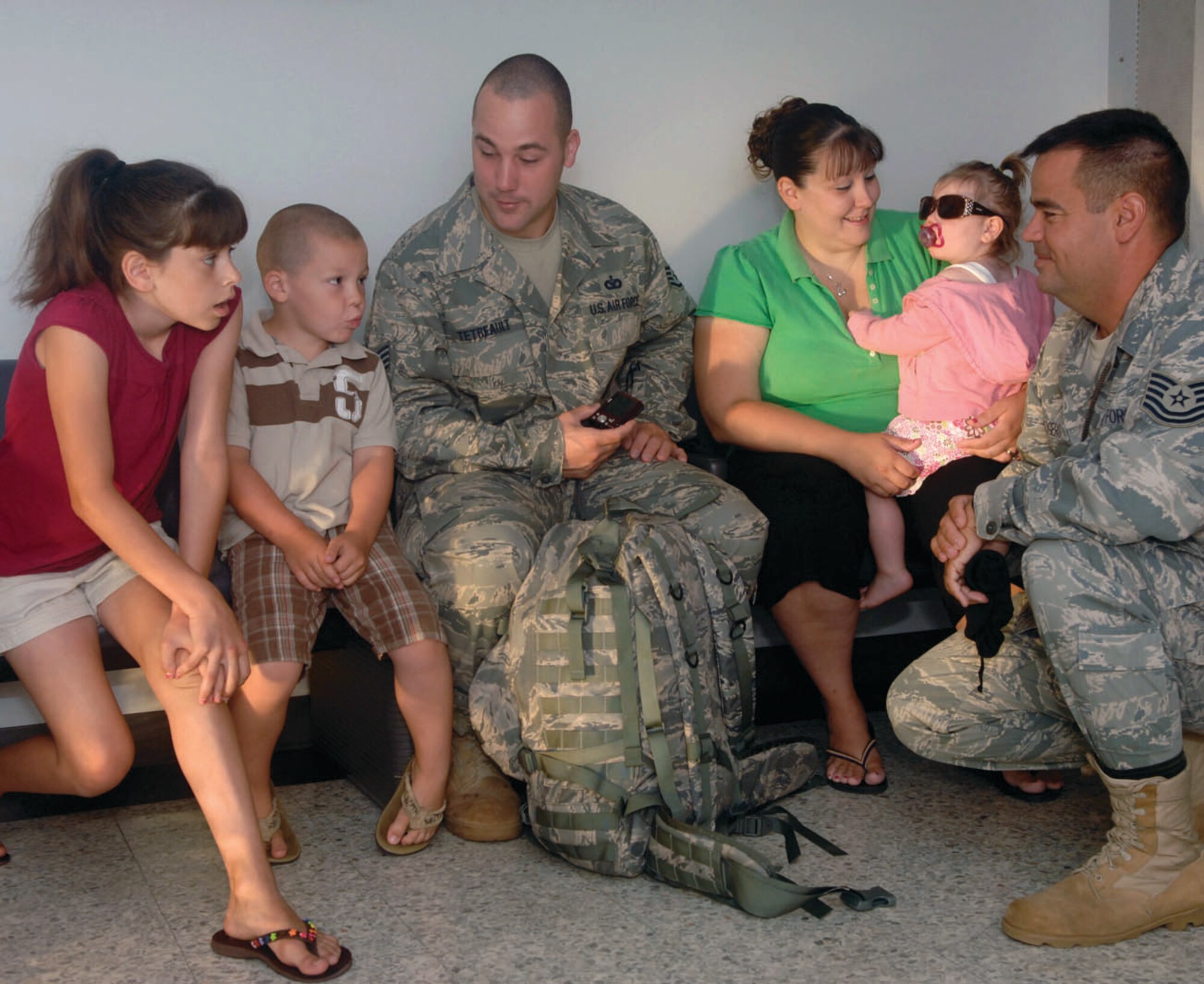 Technical Sgt. Patrick Rodgers, 316th Security Forces Squadron NCO in charge of executive services, right, talks to Staff Sgt. Joshua Tetreault, 316th Security Forces Squadron executive services team member, center, and his family at the Passenger Terminal before Sergeant Tetreault departs for training June 25. Twenty-six 316 SFS members flew to Creech Air Force Base, Nev. for training prior to deploying to Balad Air Base. (U.S. Air Force photo/ Bobby Jones)