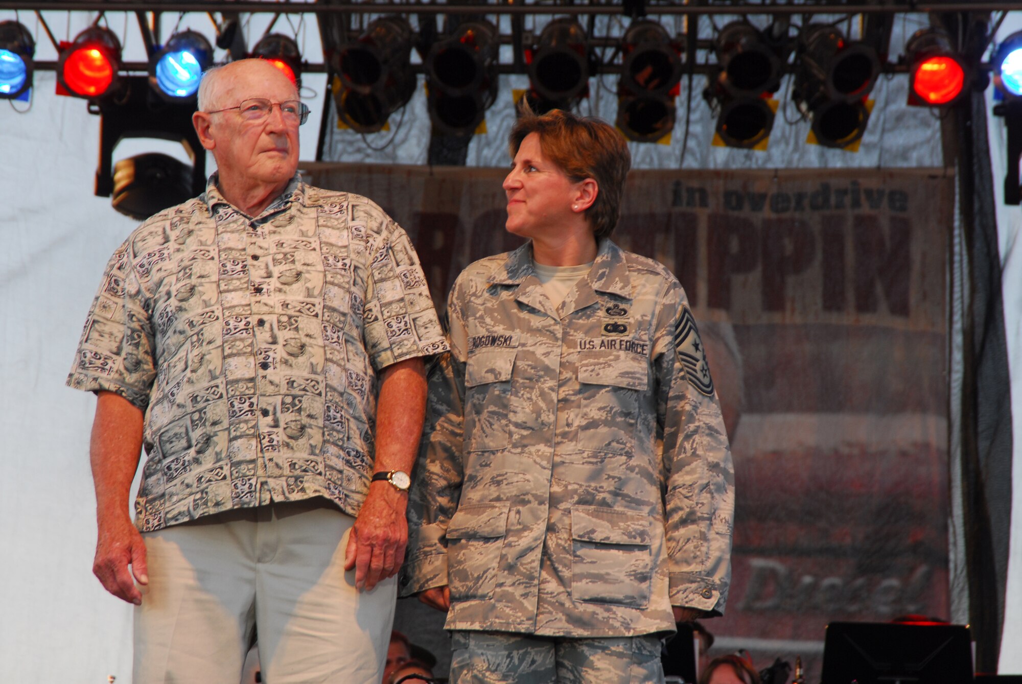 WRIGHT-PATTERSON AIR FORCE BASE, Ohio - Chief Master Sgt. Peri Rogowski, 445th Airlift Wing command chief, escorts World War II honoree, Lowell Norton, on stage during a special recognition of World War II honorees during the June 26 AFMC's Freedom's Call Tattoo 2009. (Air Force photo/Airman 1st Class Bre Shaw)