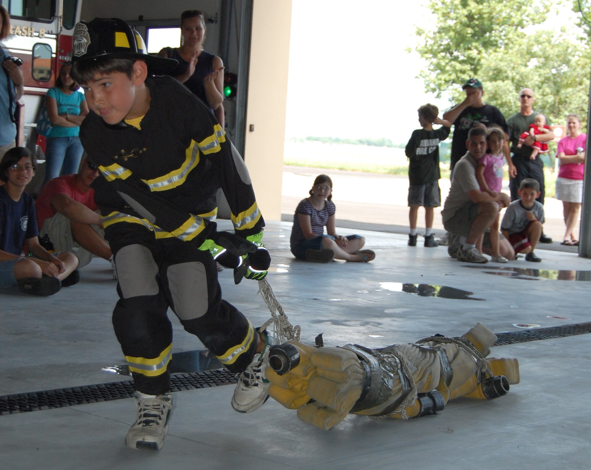 Yellow Team member Brandon Springer drags a simulated person to a nearby stretcher during the Aviano Fire Camp relay competition July 3, 2009. The week-long camp, which was open to 10-13-year-old base children, taught attendees basic firefighter knowledge and skills. (U.S. Air Force photo/Staff Sgt. Lindsey Maurice)