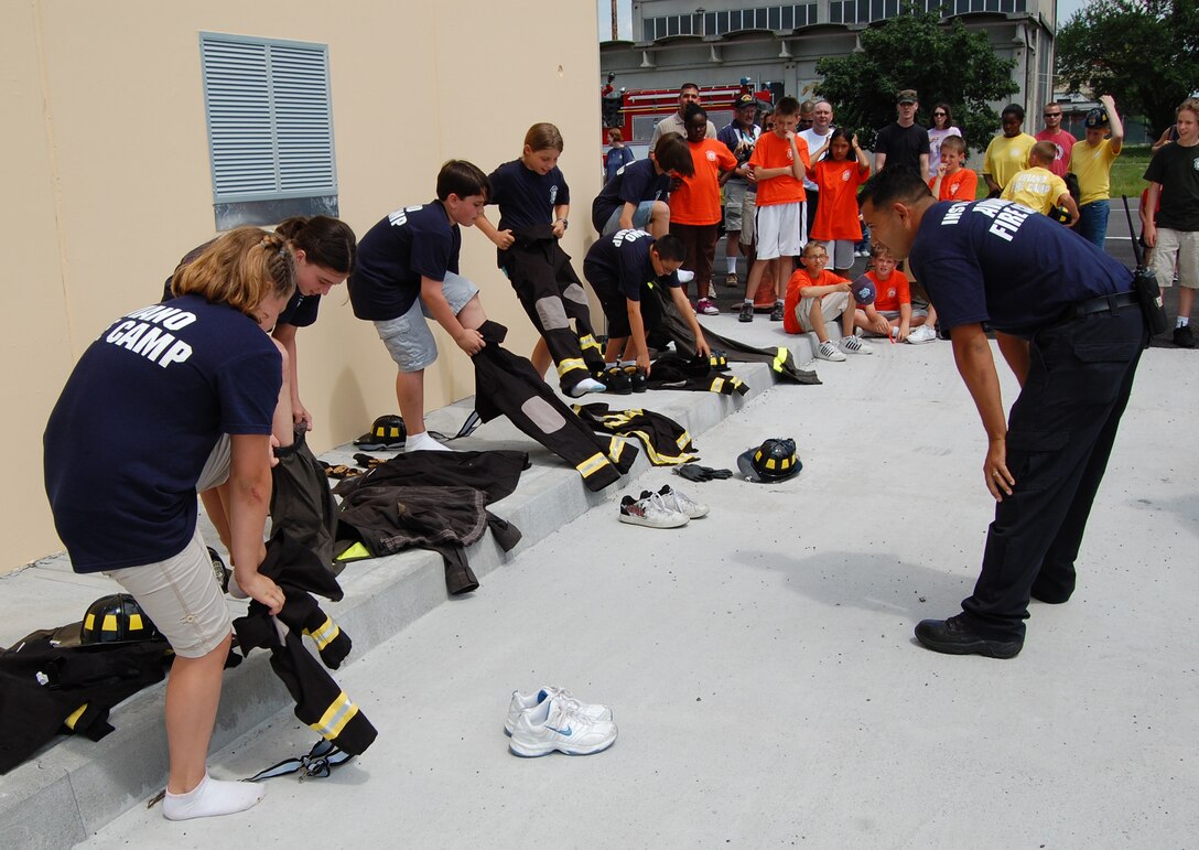 Blue Team members don their firefighter suits as part of the Aviano Fire Camp relay competition July 3, 2009 at the base fire station. The week-long camp taught children basic firefighter knowledge and skills. (U.S. Air Force photo/Staff Sgt. Lindsey Maurice)