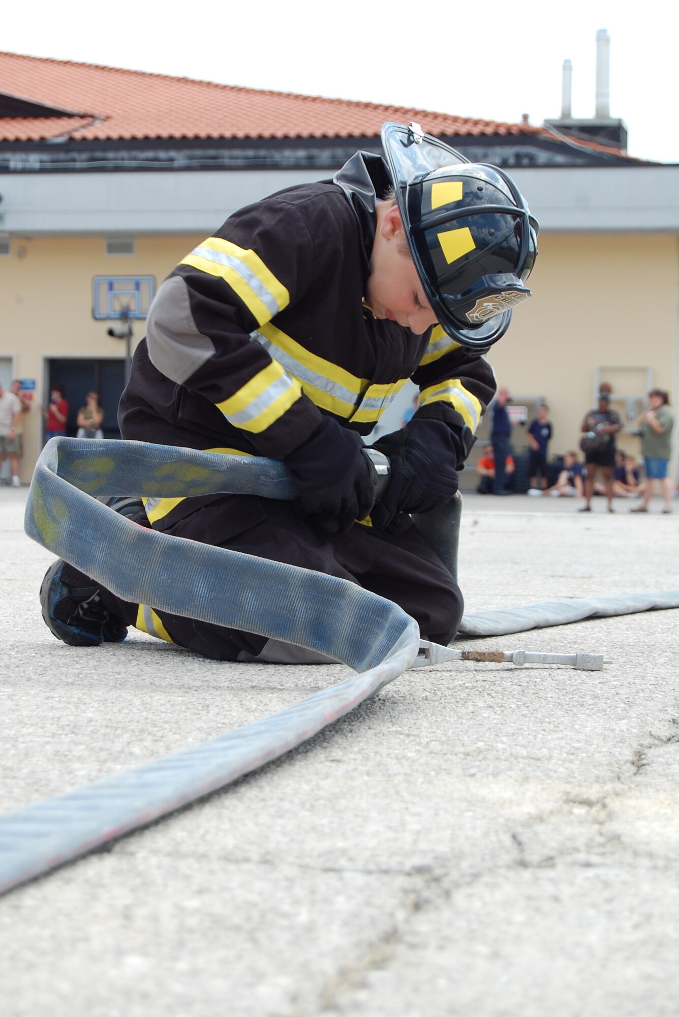 Red Team member Cody Gummerson hooks up a fire hose as part of the Aviano Fire Camp relay competition July 3, 2009 at the base fire station. The week-long camp, which was open to 10-13-year-old children, taught attendees basic firefighter knowledge and skills. (U.S. Air Force photo/Staff Sgt. Lindsey Maurice)