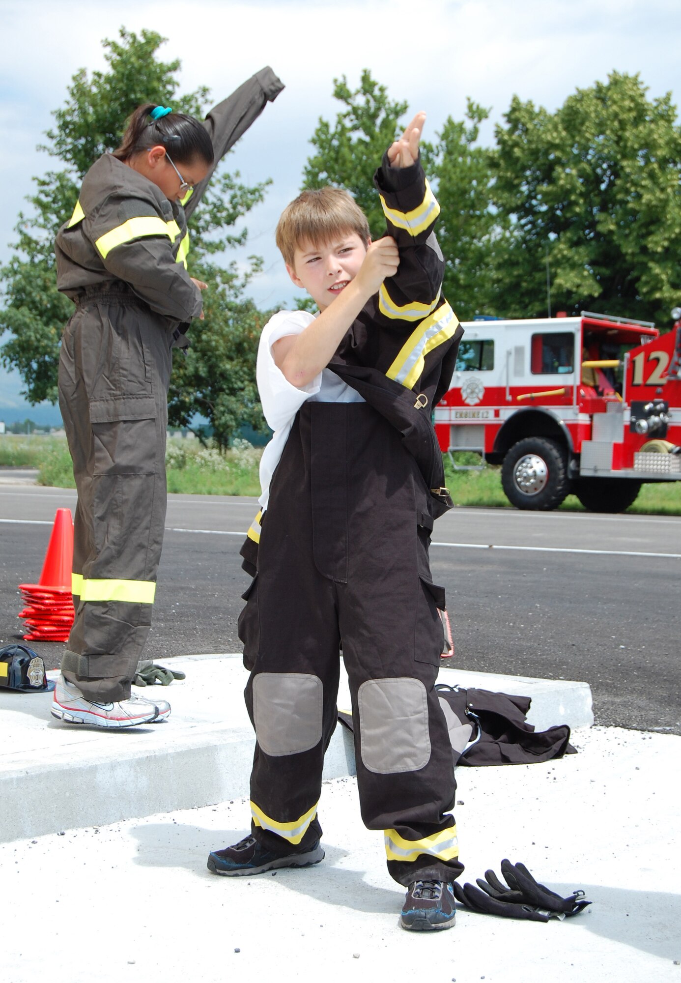 Red Team members Kameron Sandoval (left) and Cody Gummerson don their firefighter suits as part of an Aviano Fire Camp relay competition July 3, 2009. The week-long camp was open to 10-13-year-old base children. (U.S. Air Force photo/Staff Sgt. Lindsey Maurice)