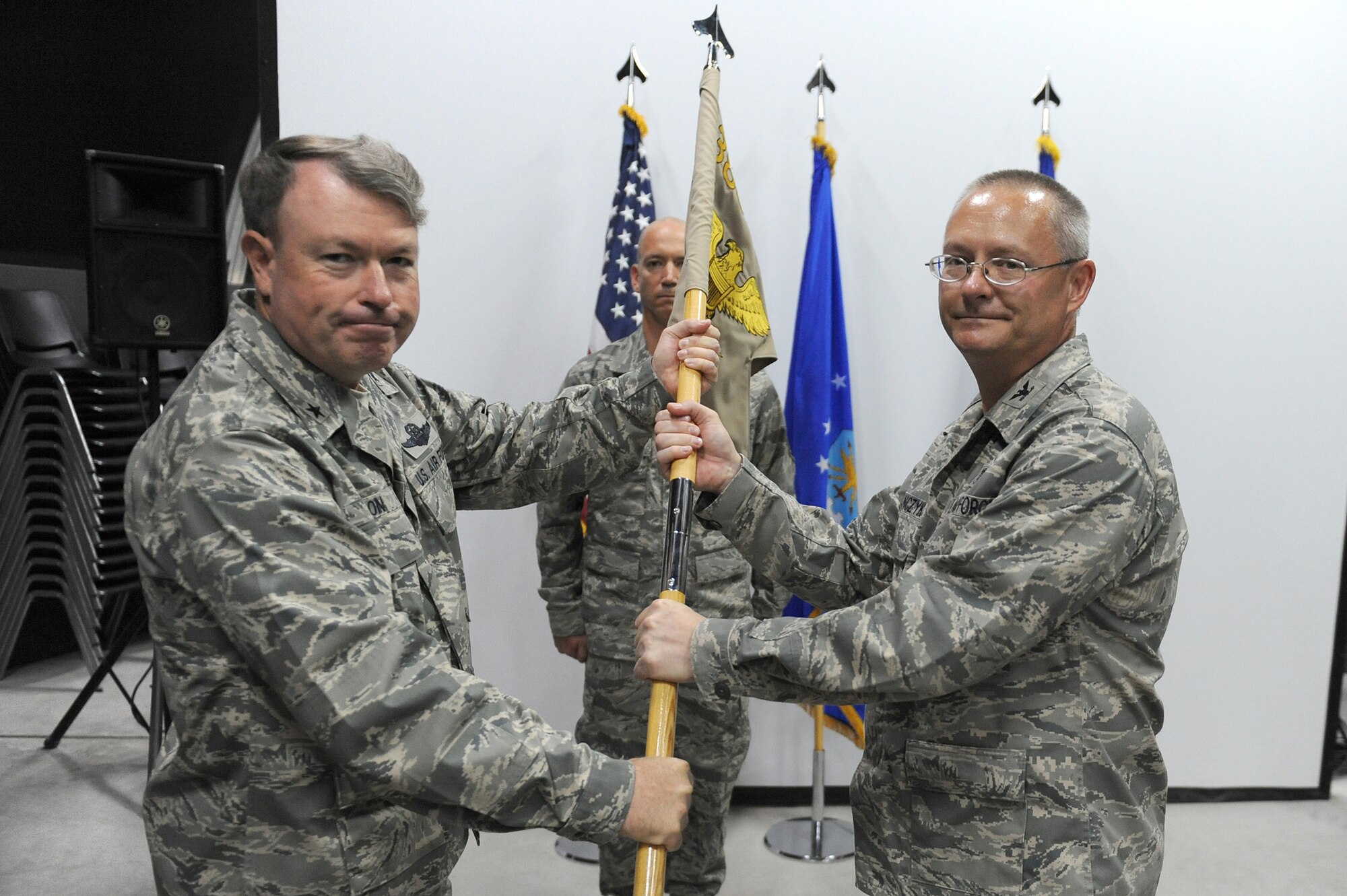 SOUTHWEST ASIA - Brig. Gen. Bryan Benson, 380th Air Expeditionary Wing, commander, passes the guidon of the 380th Expeditionary Medical Group to Col. David Stanczyk as he takes command, July 2 at an undisclosed location in Southwest Asia. Colonel Stanczyk comes from Little Rock AFB, Ark. joining the 380th Air Expeditionary Wing to lead the 380th EMDG. (U.S. Air Force photo by Senior Airman Brian J. Ellis)